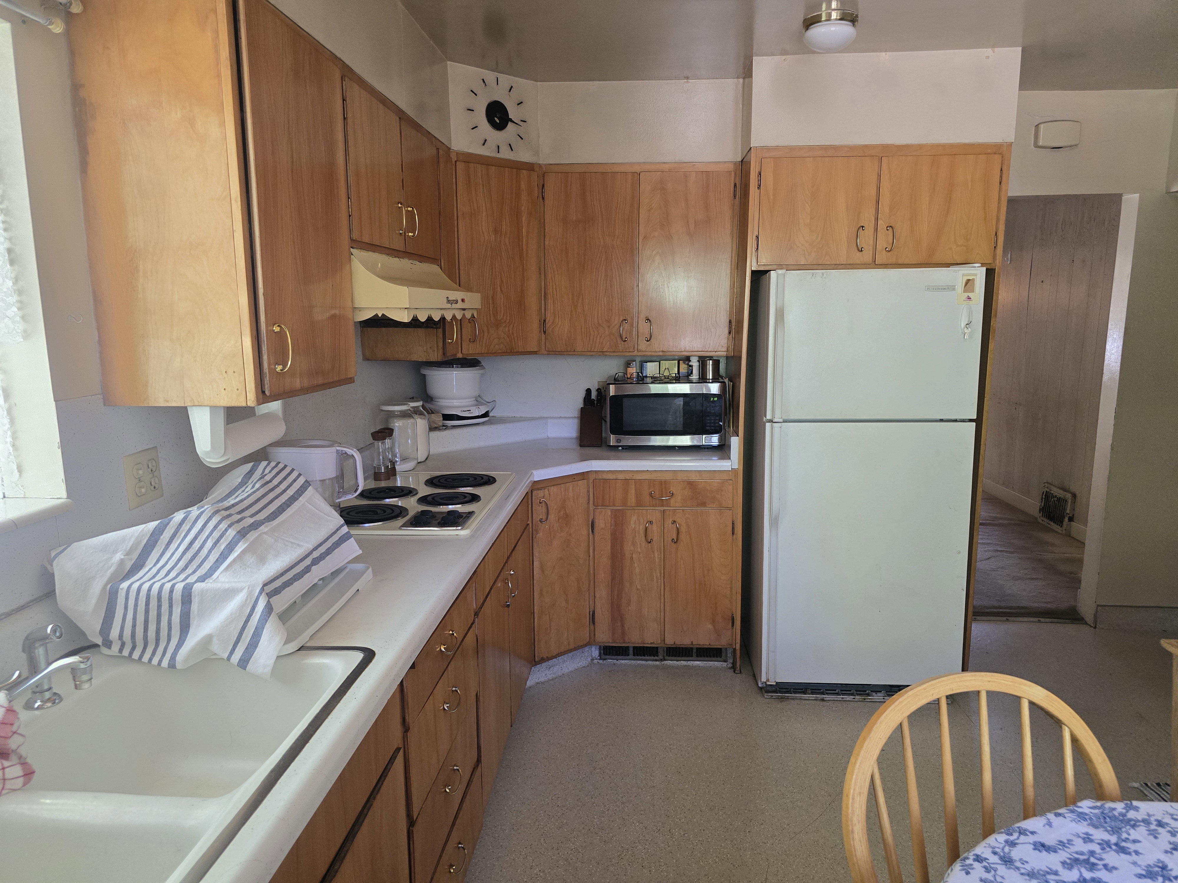 Kitchen featuring wood cabinetry, white countertops, an integrated sink, a white electric range, and a white refrigerator