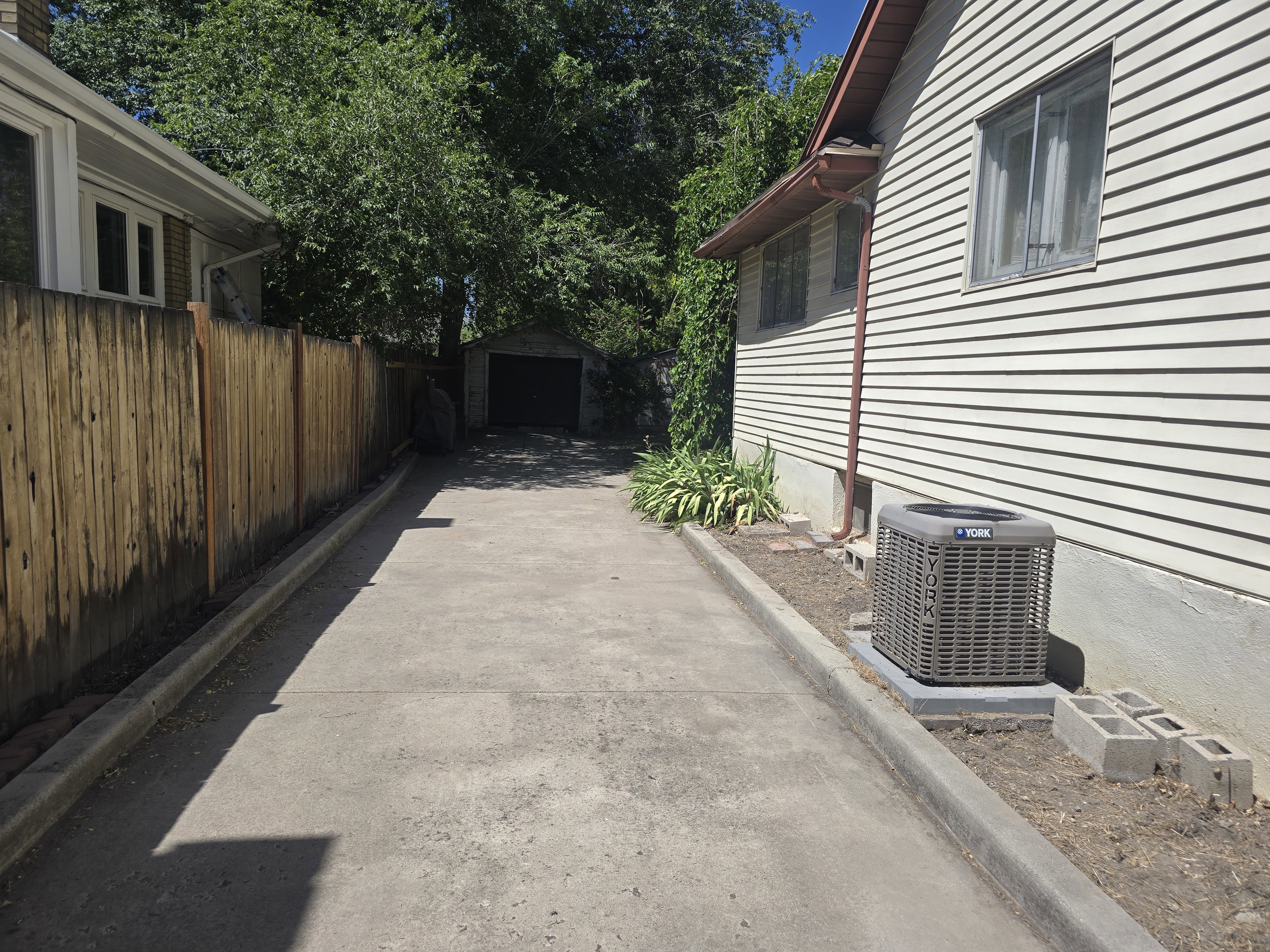 Gated driveway with concrete surfacing and an exterior garage