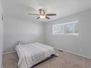 Carpeted room featuring a ceiling fan with integrated lighting, a window with horizontal blinds, and light gray wall paint