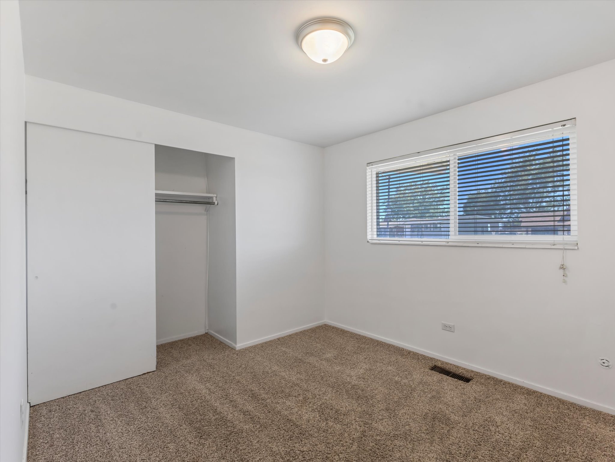 Light-colored carpeting and white walls create a neutral palette
