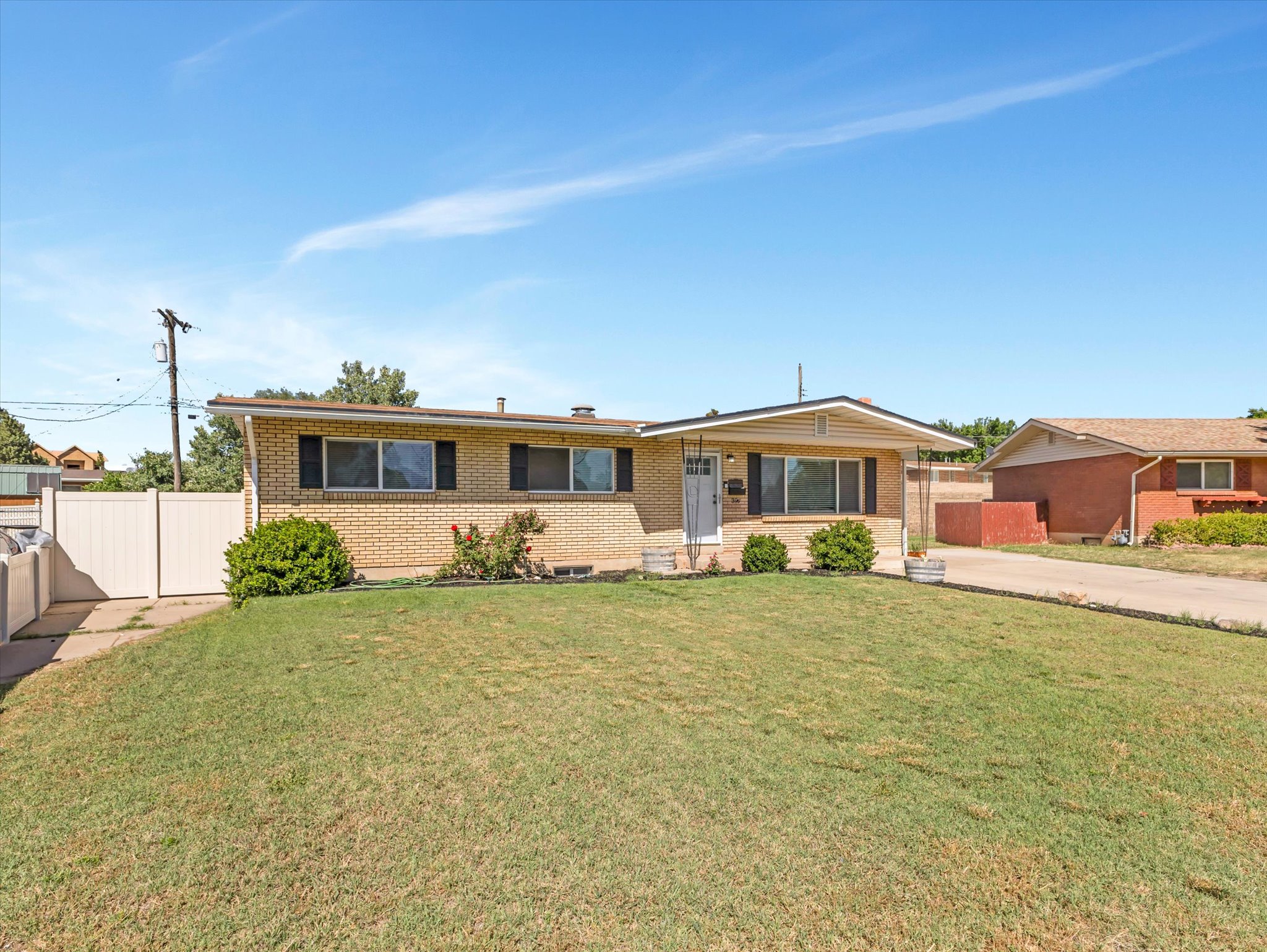 Ranch-style residence featuring a brick facade and a wide front lawn