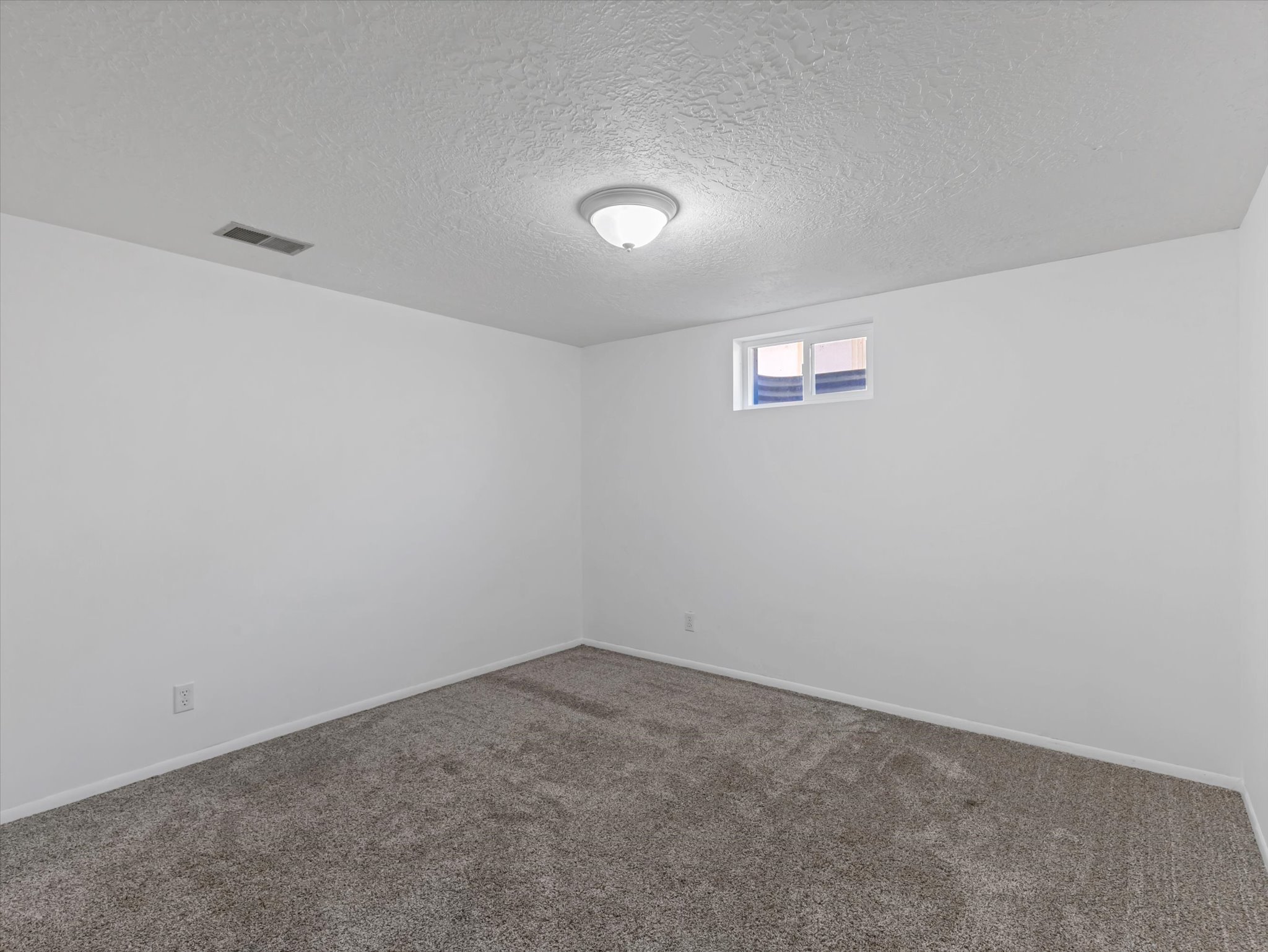 Neutral color palette featuring white walls and textured gray carpeting