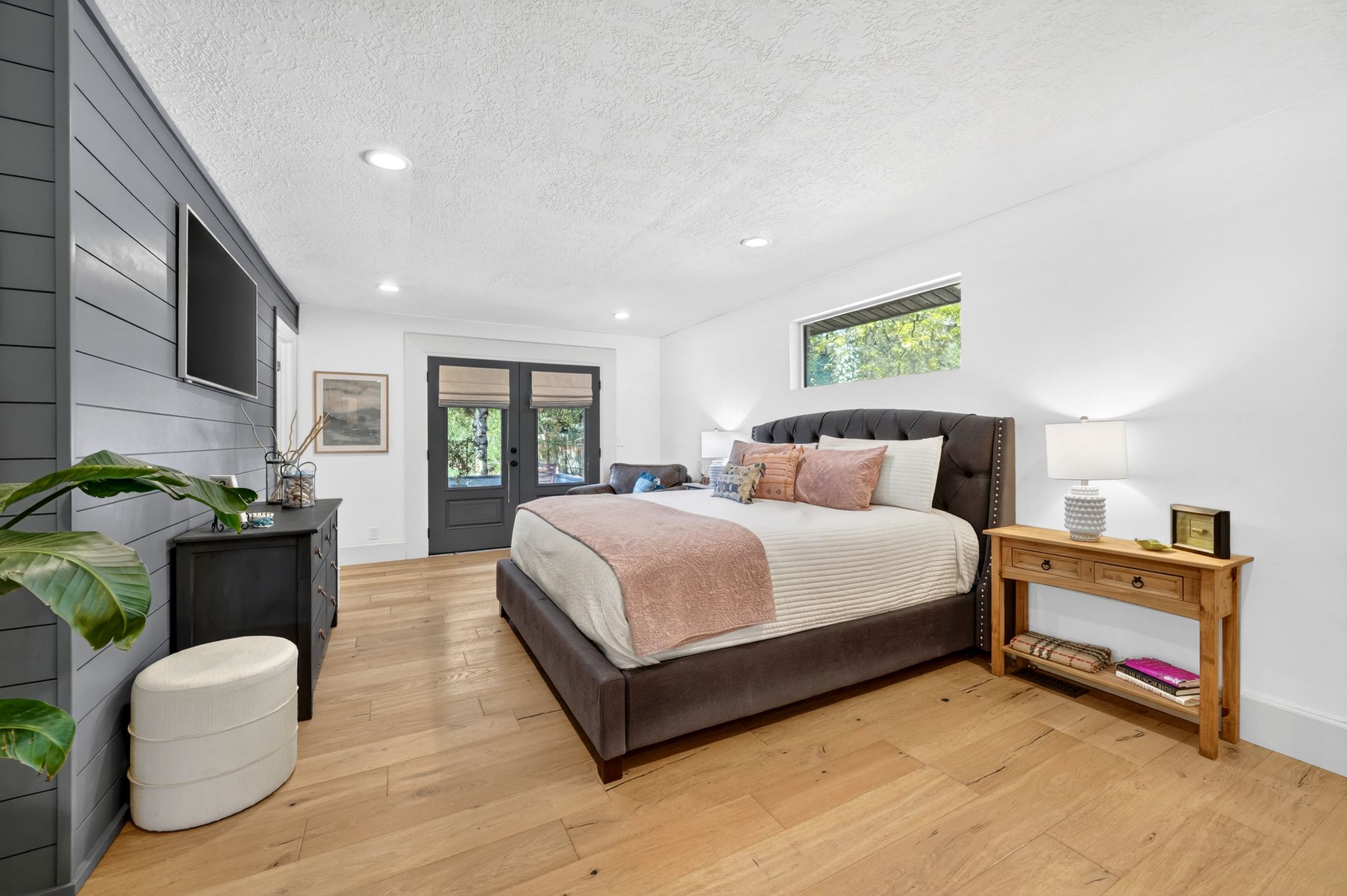 Spacious room featuring light wood-finish flooring and a shiplap accent wall