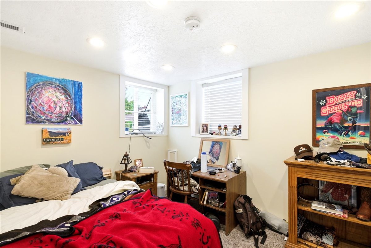 Carpeted room featuring recessed lighting and two windows with blinds