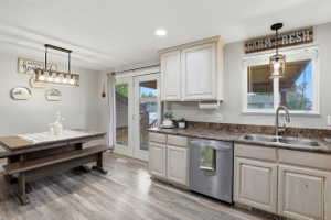 Kitchen featuring wood-finish flooring, white cabinetry, a double basin stainless steel sink, and stainless steel appliances