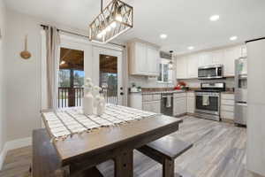 Kitchen featuring light cabinetry, stainless steel appliances, and wood-finish flooring