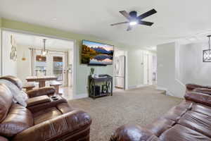 Spacious living area featuring neutral carpet flooring and light green wall tones