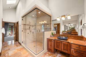 Bathroom featuring vanity, a high ceiling, a stall shower, and recessed lighting