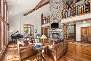 Living room featuring a fireplace, hardwood / wood-style flooring, vaulted ceiling, and recessed lighting