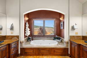 Full bathroom with vanity and a tub with jets