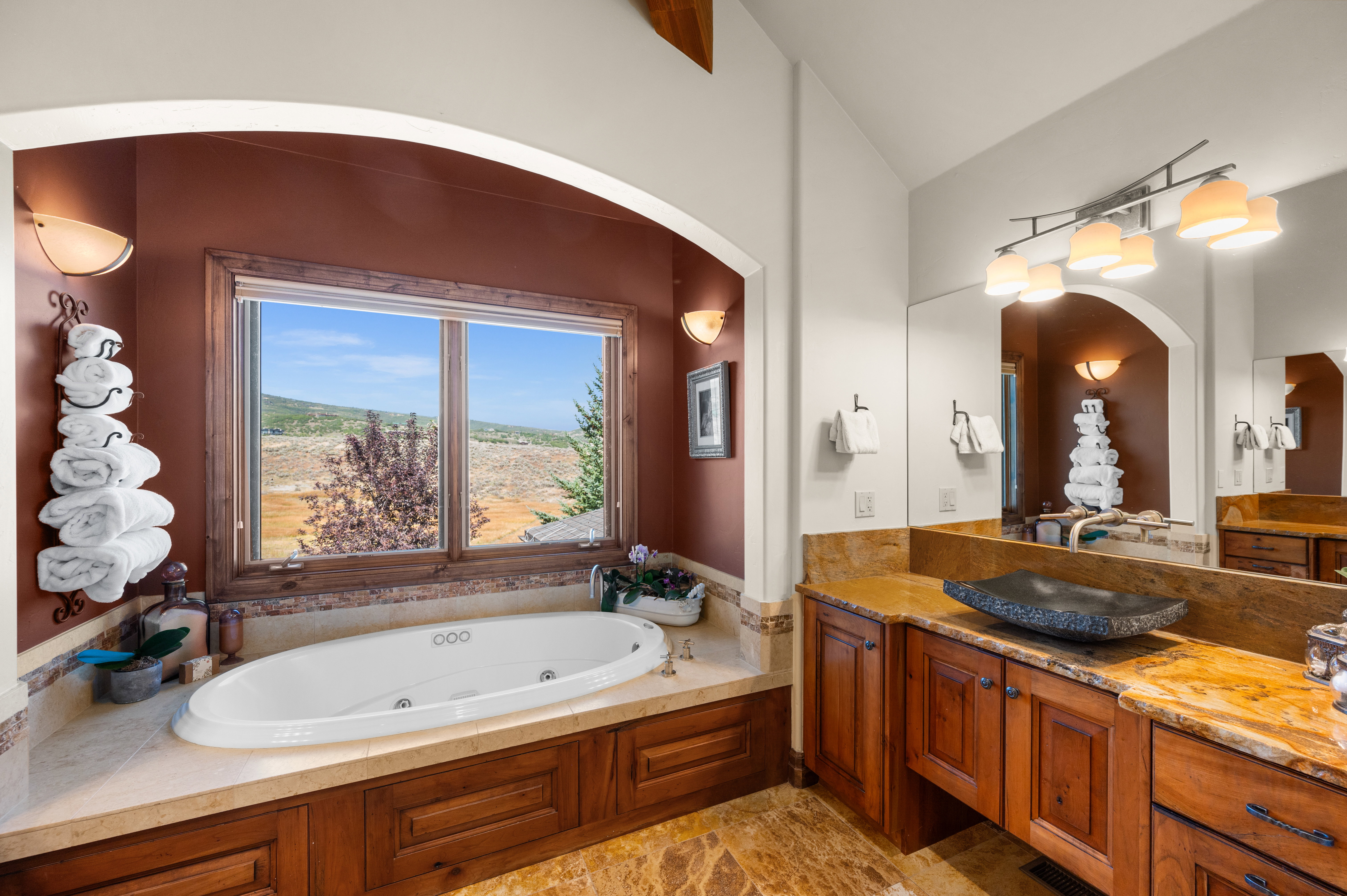 Full bathroom with vanity, vaulted ceiling, and a whirlpool tub
