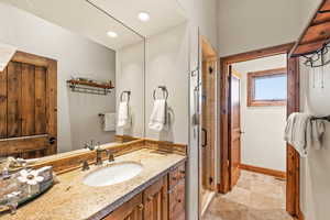 Full bathroom with vanity, a shower stall, light stone finish floors, and recessed lighting