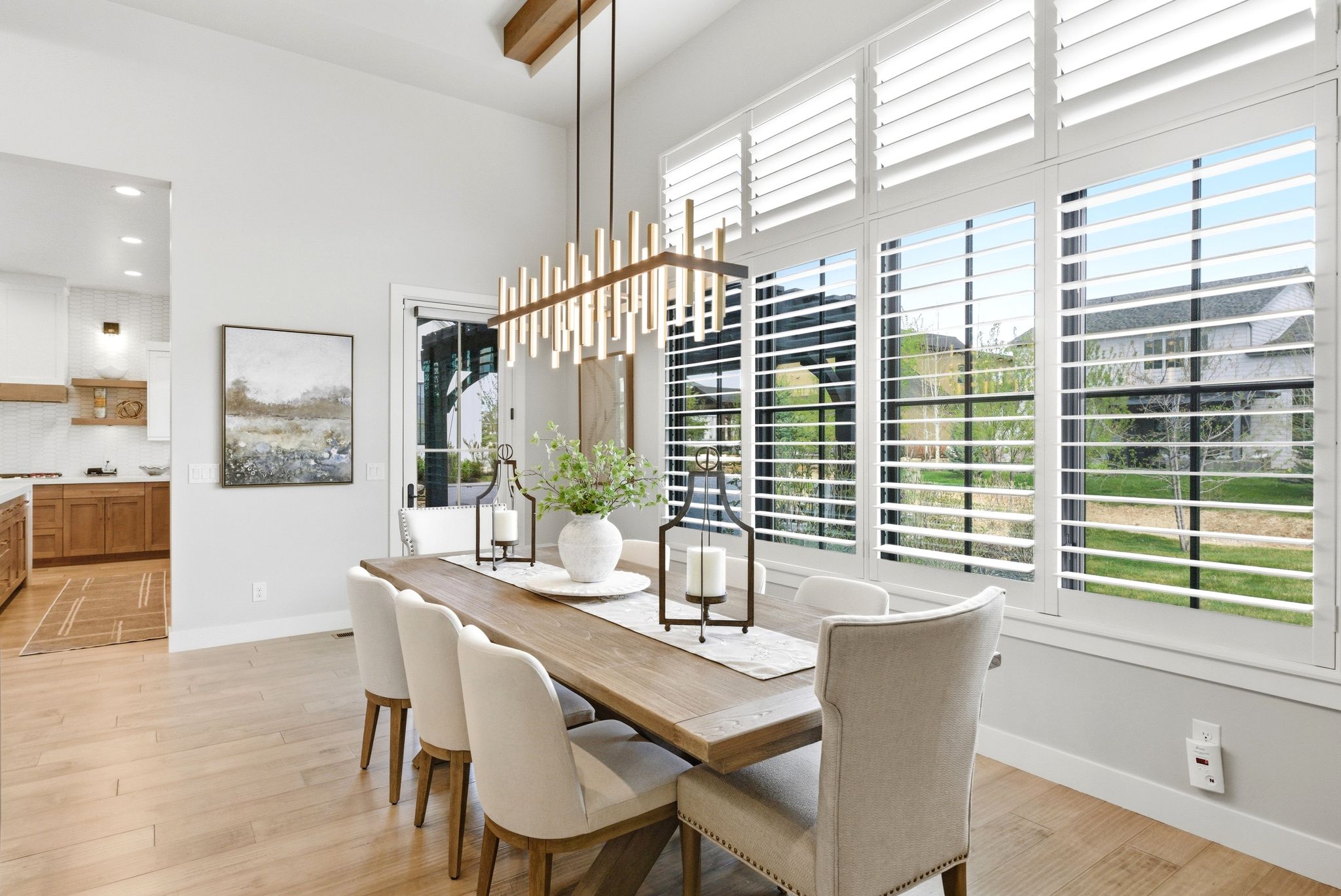 Dining area featuring high ceilings, wood-finish flooring, and a linear chandelier