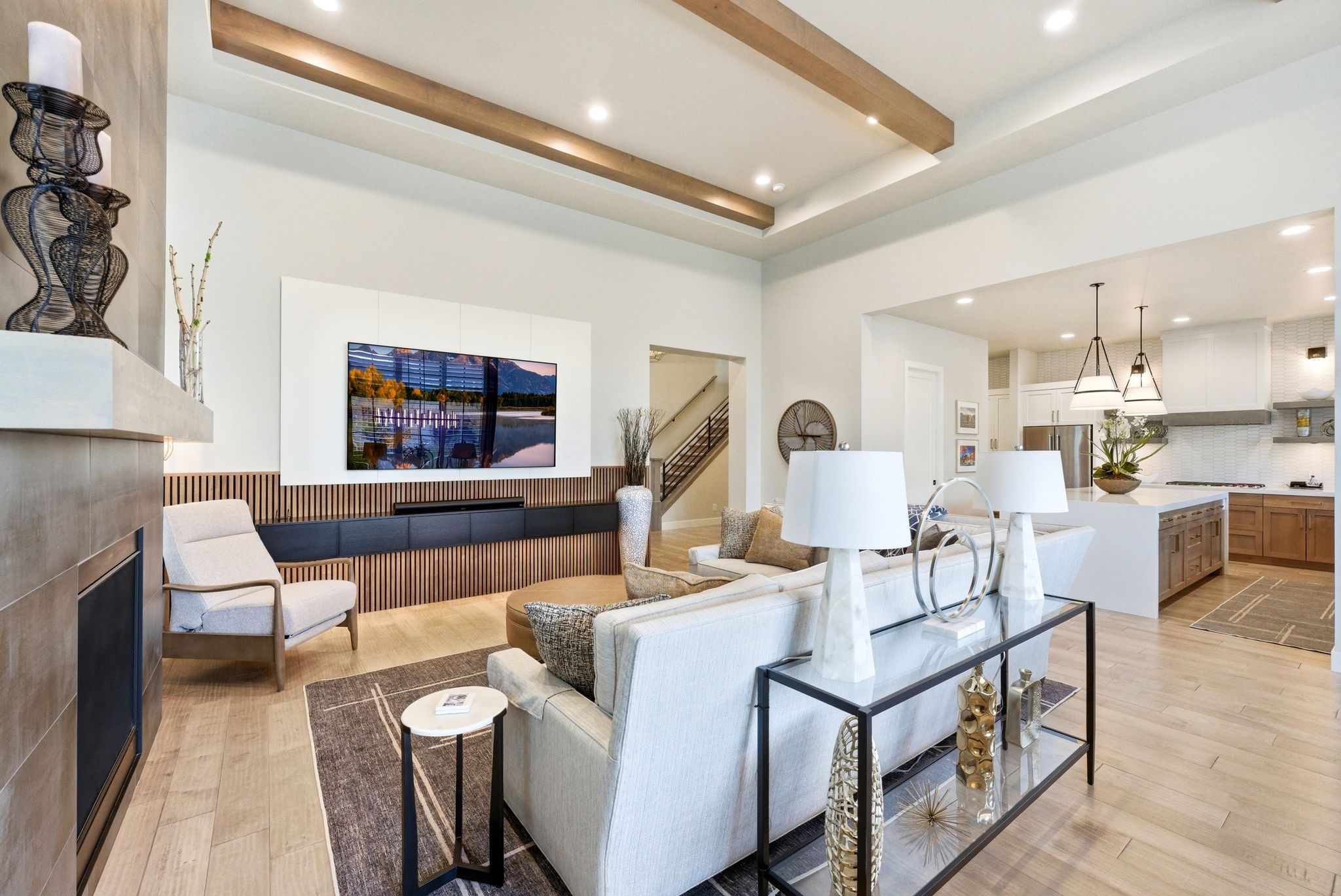 Living area featuring wood-finish flooring, a fireplace with a stone surround, and an integrated media wall