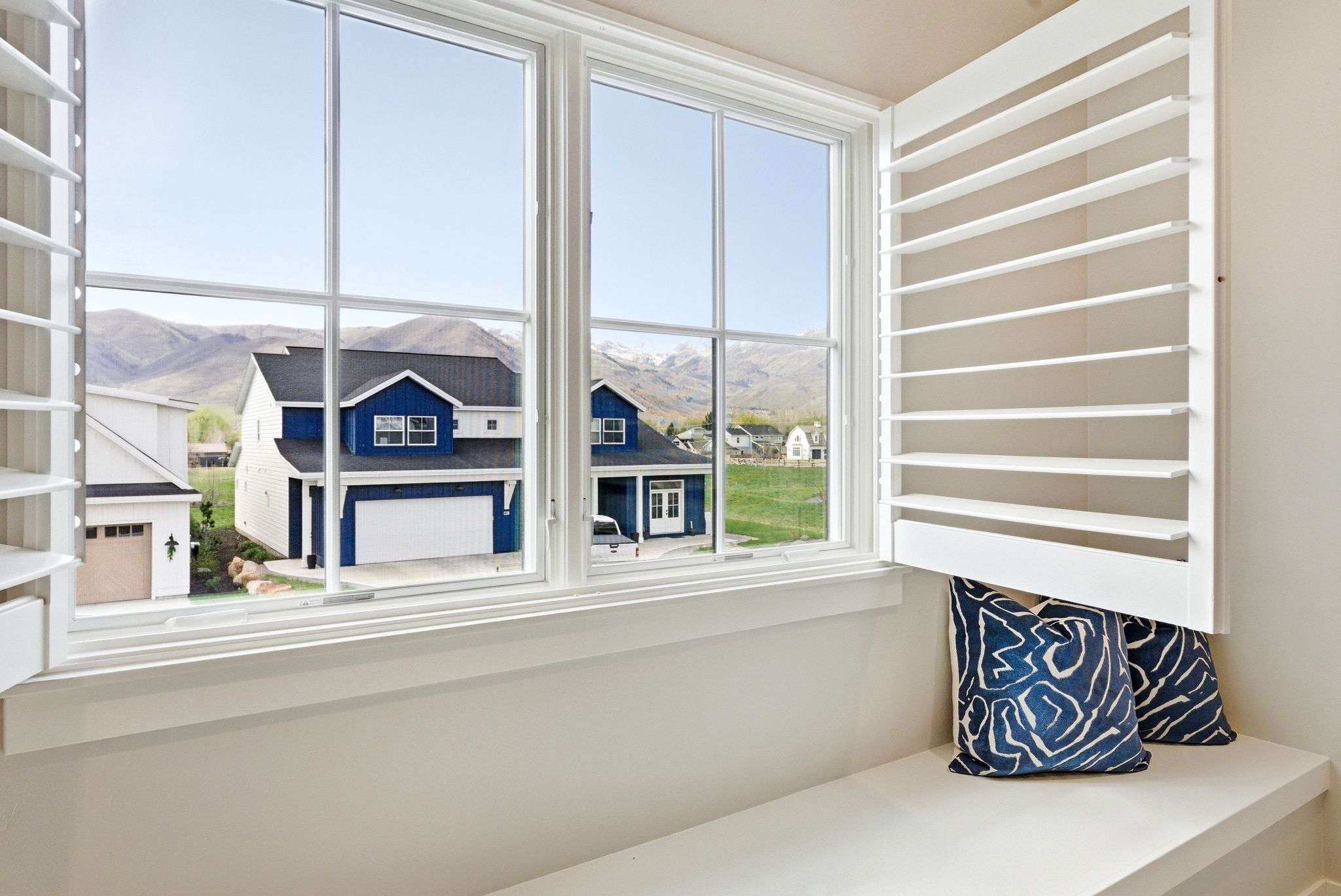 Window with white plantation shutters and a built-in window seat