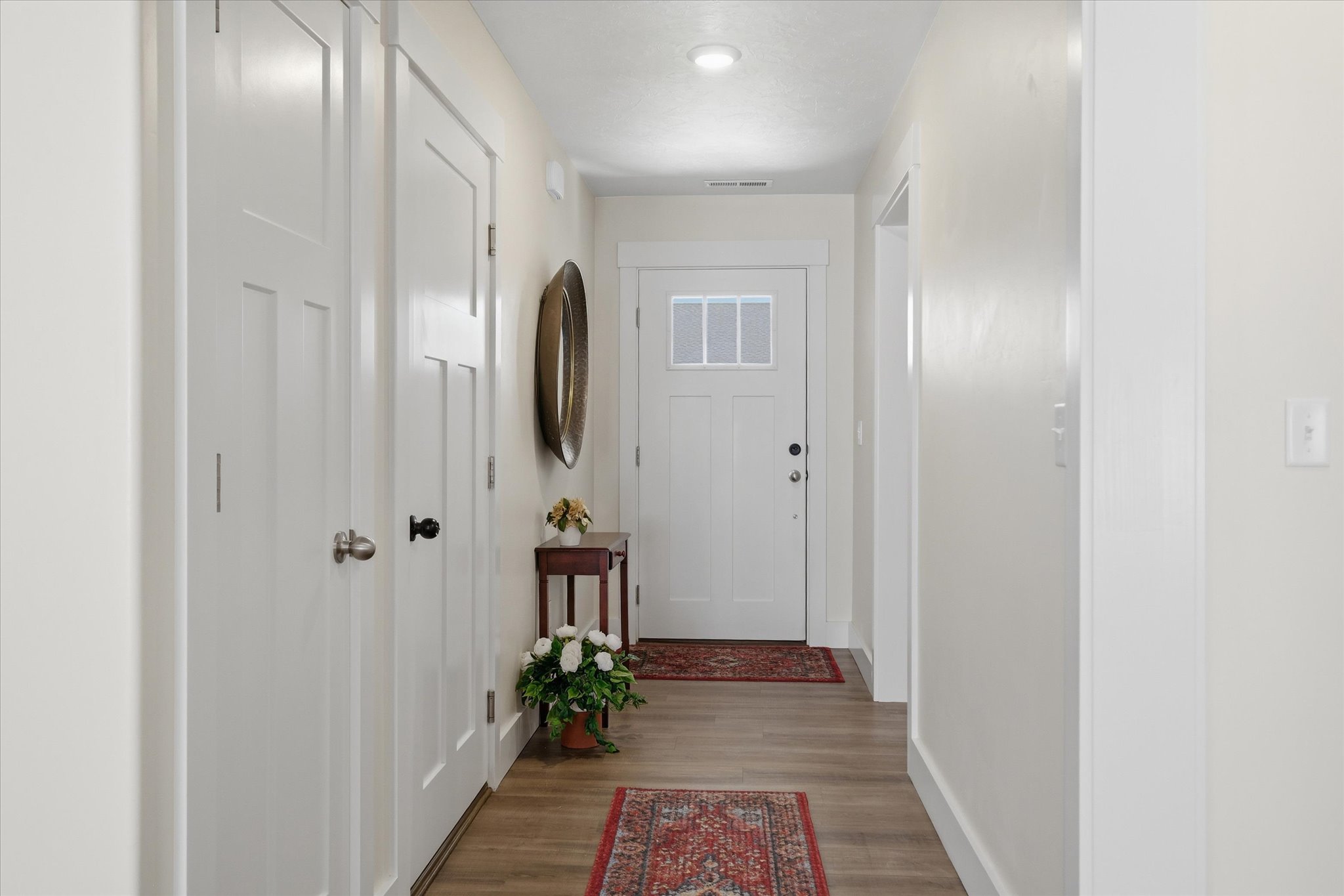 Entryway featuring wood-finish flooring, recessed lighting, and a white paneled door with window lites