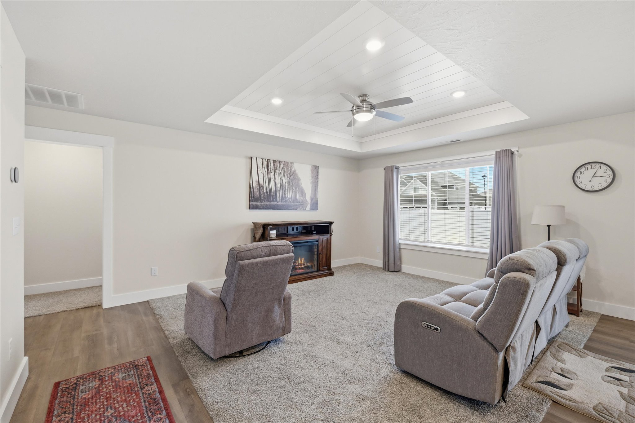 Living area featuring a tray ceiling with shiplap detailing, recessed lighting, and a ceiling fan