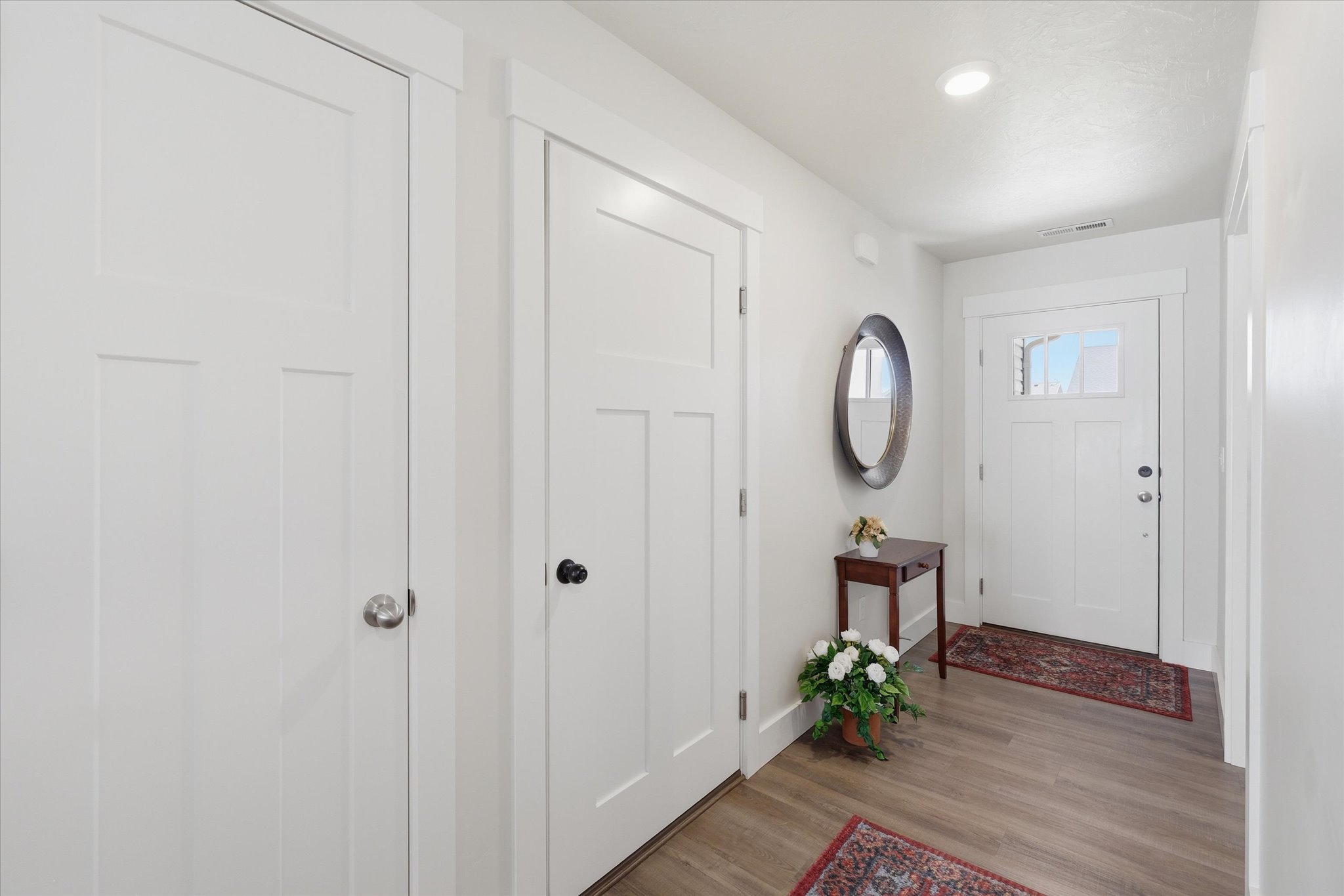 Entryway featuring wood-finish flooring, recessed lighting, and a white paneled door with an integrated window