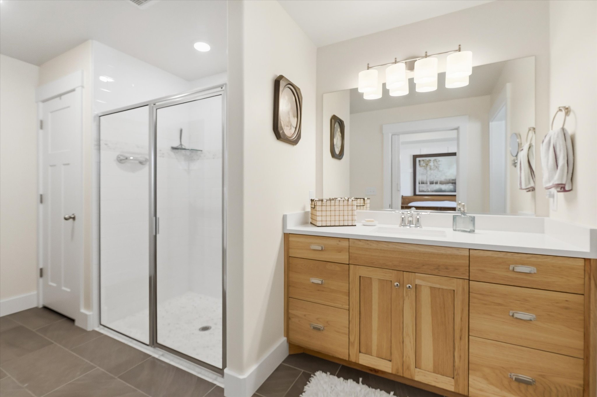 Spacious bathroom featuring a double vanity with light wood cabinetry and a white countertop