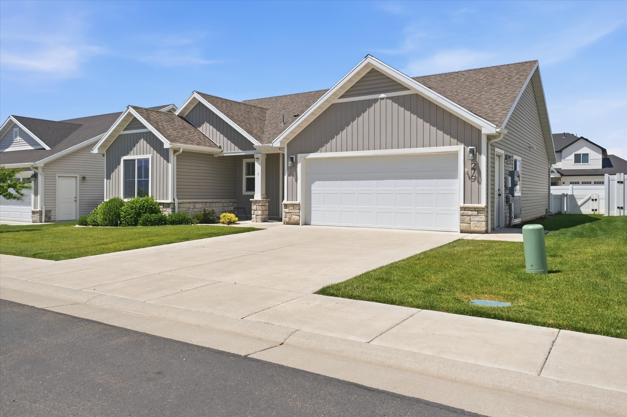 Modern ranch-style exterior featuring light gray siding and stone accents