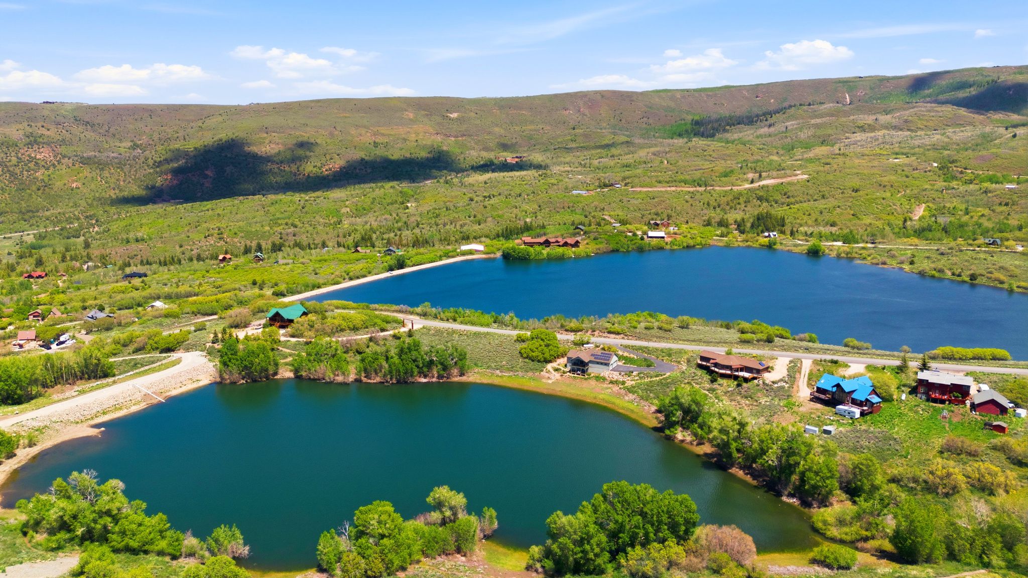 Aerial perspective showcasing two distinct bodies of water surrounded by verdant hillsides