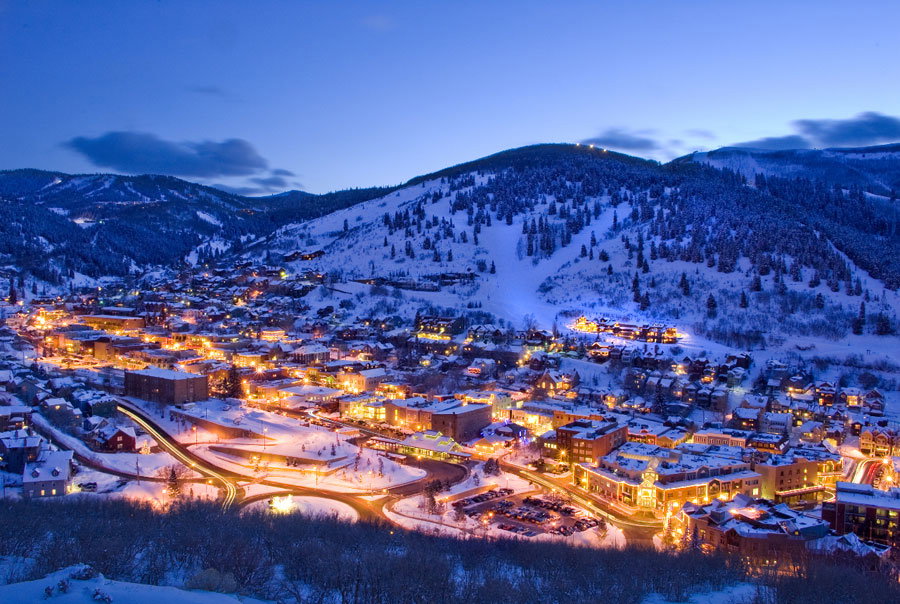Extensive aerial perspective showcasing a snow-covered mountain town at dusk