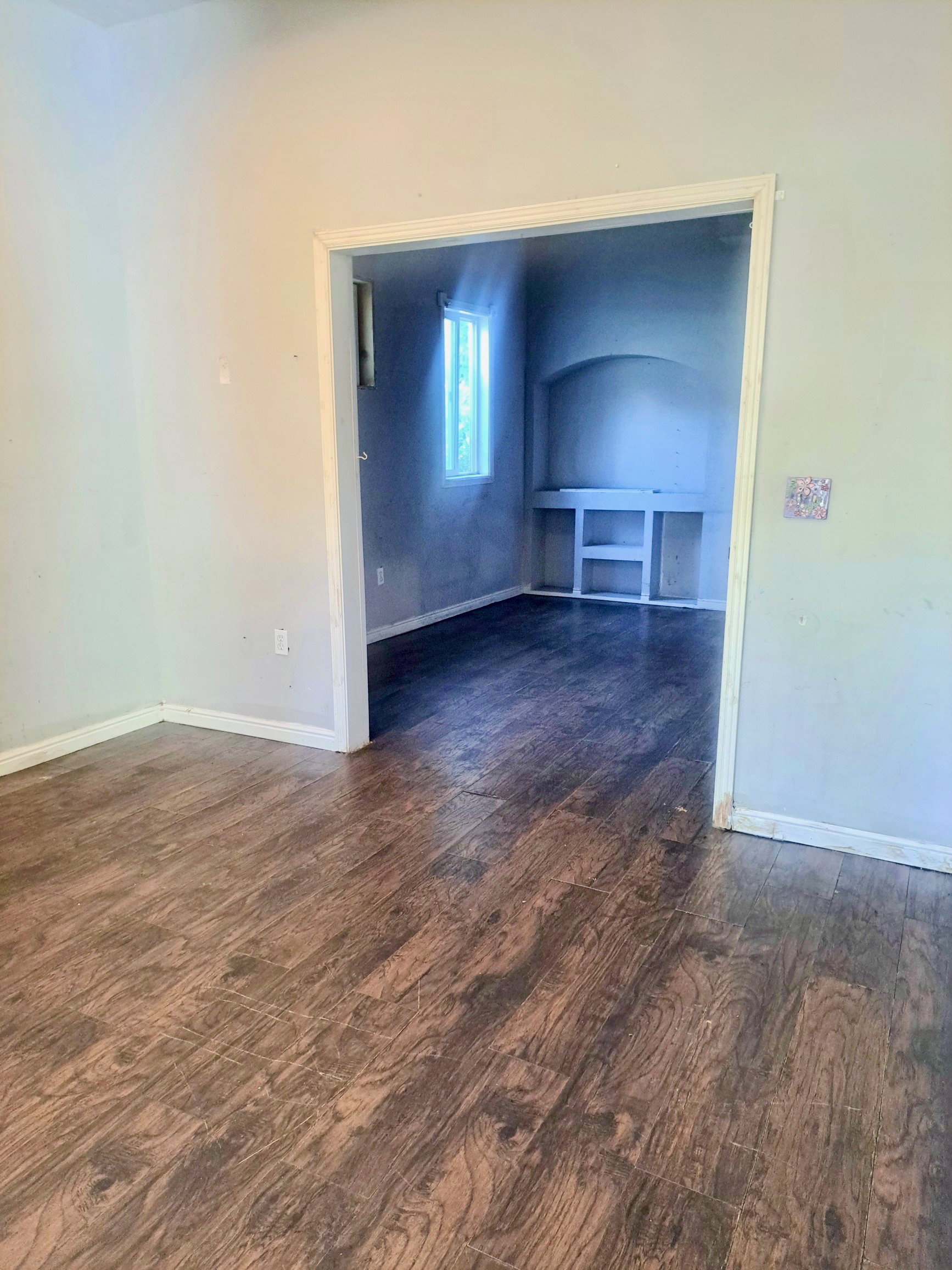 Wood-finish flooring throughout, with a framed opening to an additional room