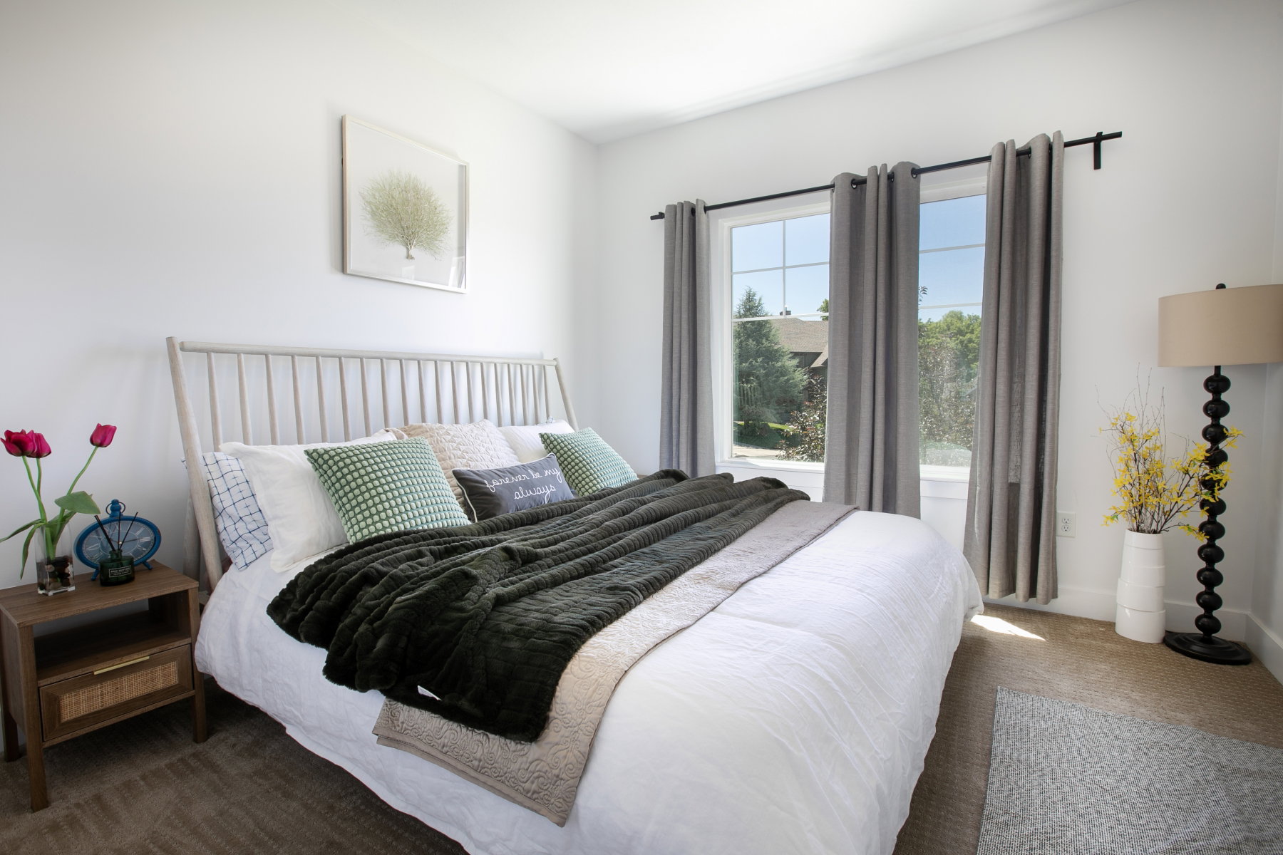 Bedroom with neutral wall paint and carpeting, featuring a window with a multi-pane grid