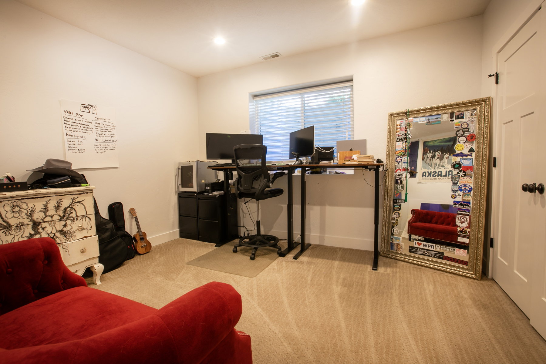 Carpeted room with a window featuring horizontal blinds, recessed lighting, and a white paneled door with dark hardware