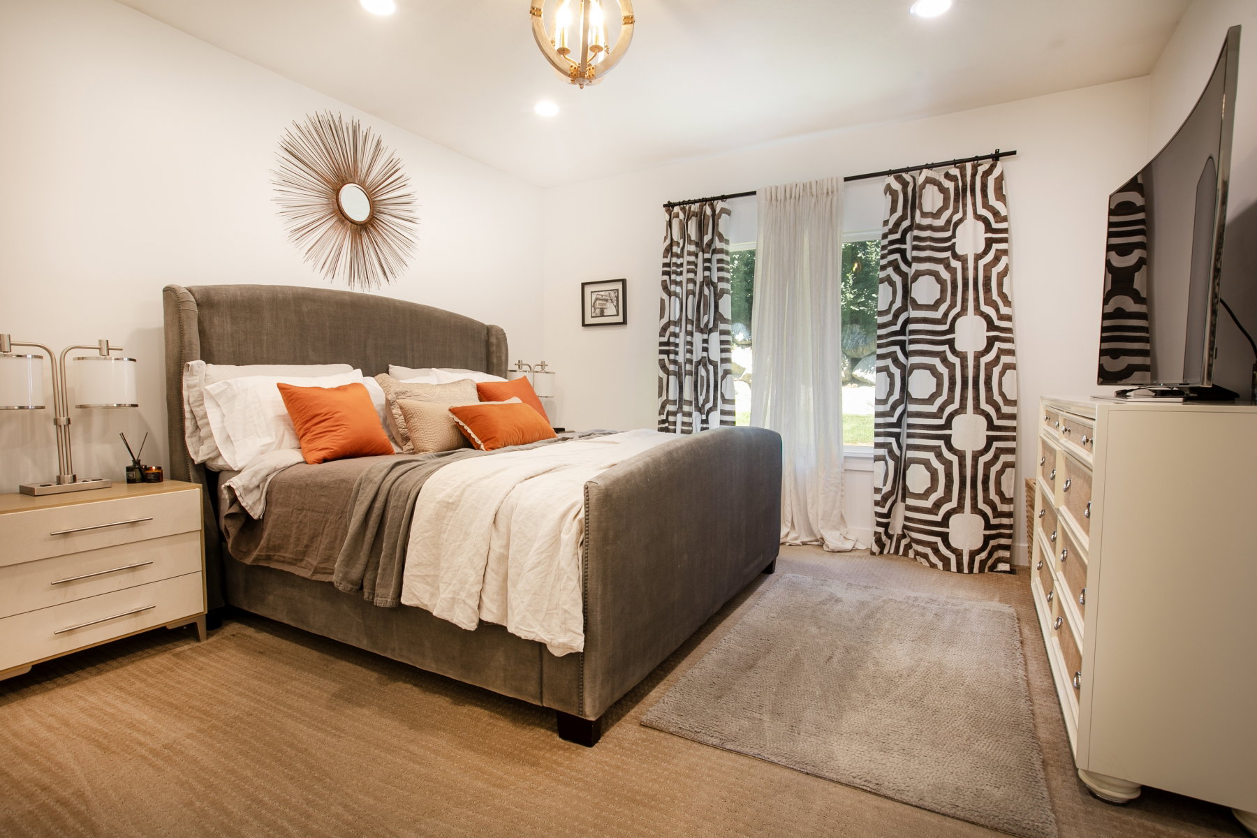 Carpeted bedroom featuring recessed lighting, a decorative ceiling fixture, and a large window with patterned drapes