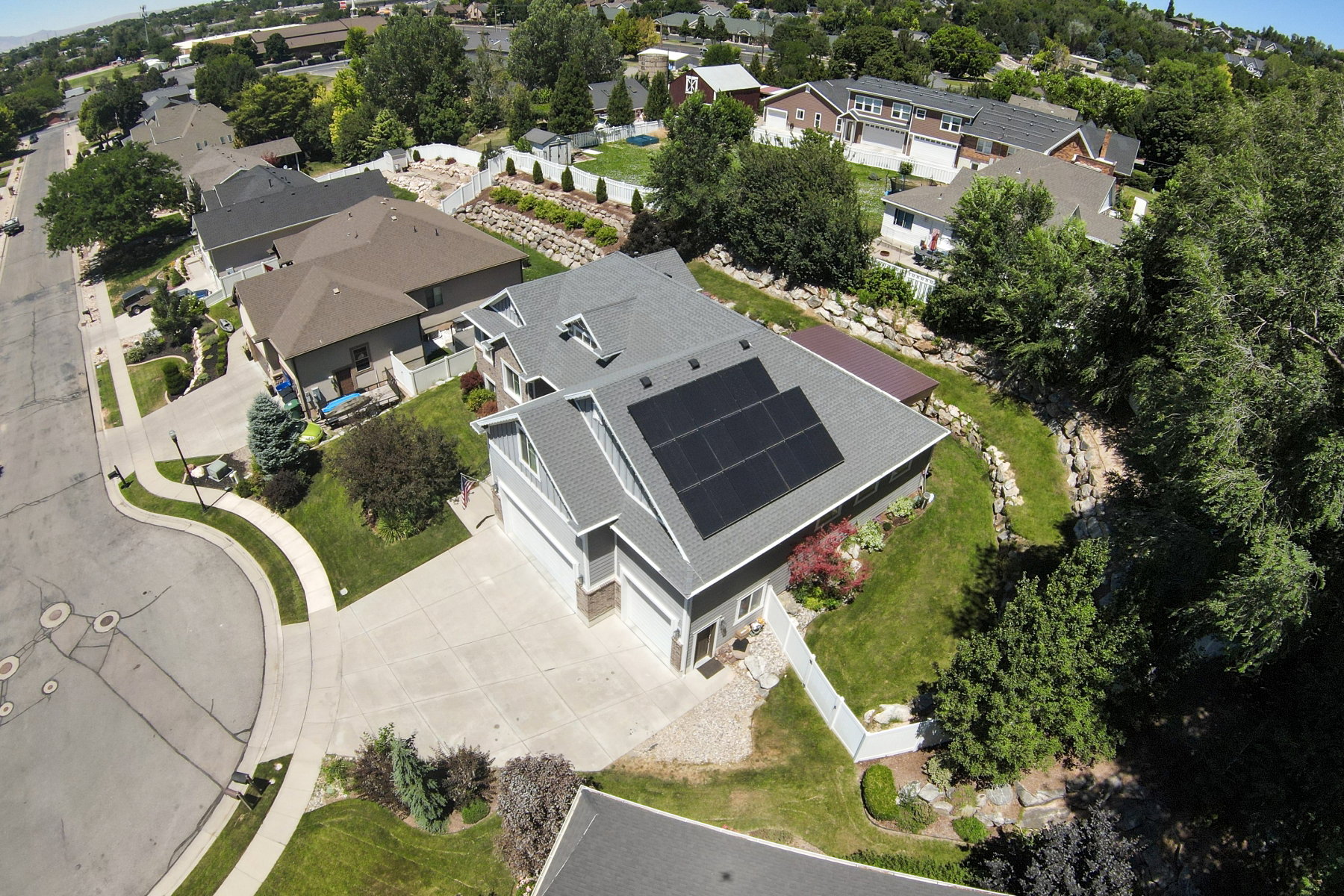 Two-story residence featuring a gray exterior siding and a multi-gabled roofline with solar panels
