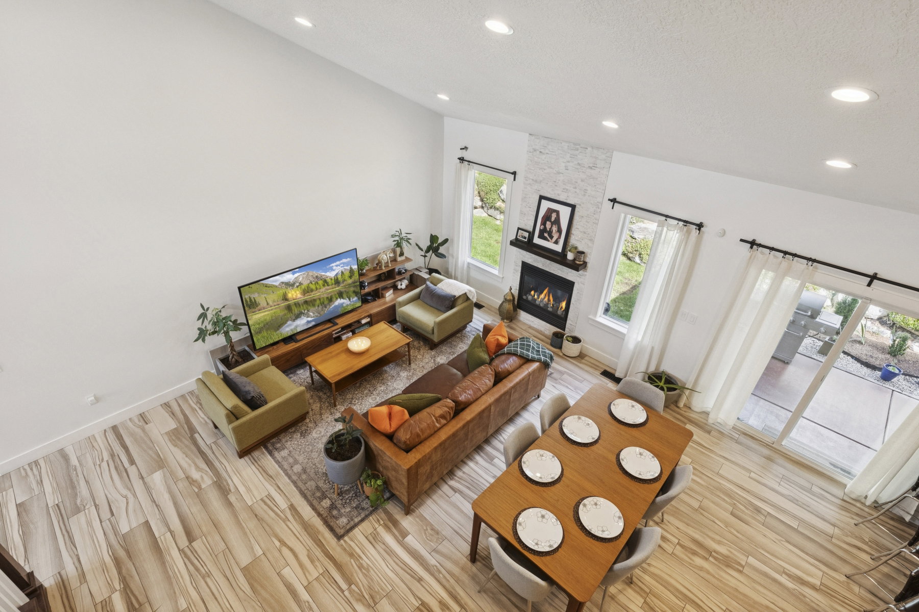 Living room featuring light wood-style flooring, a large fireplace, recessed lighting, and a textured ceiling