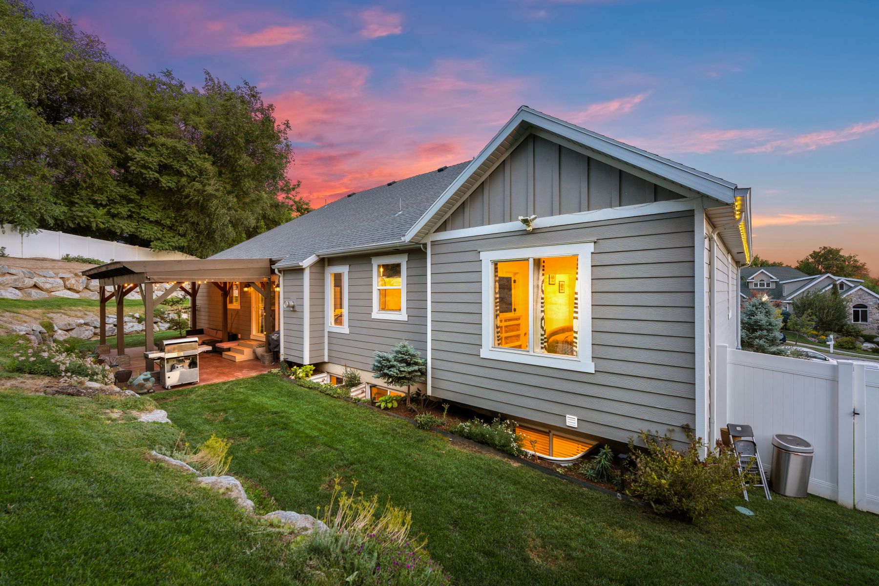 Rear view of house with board and batten siding, a patio, and roof with shingles