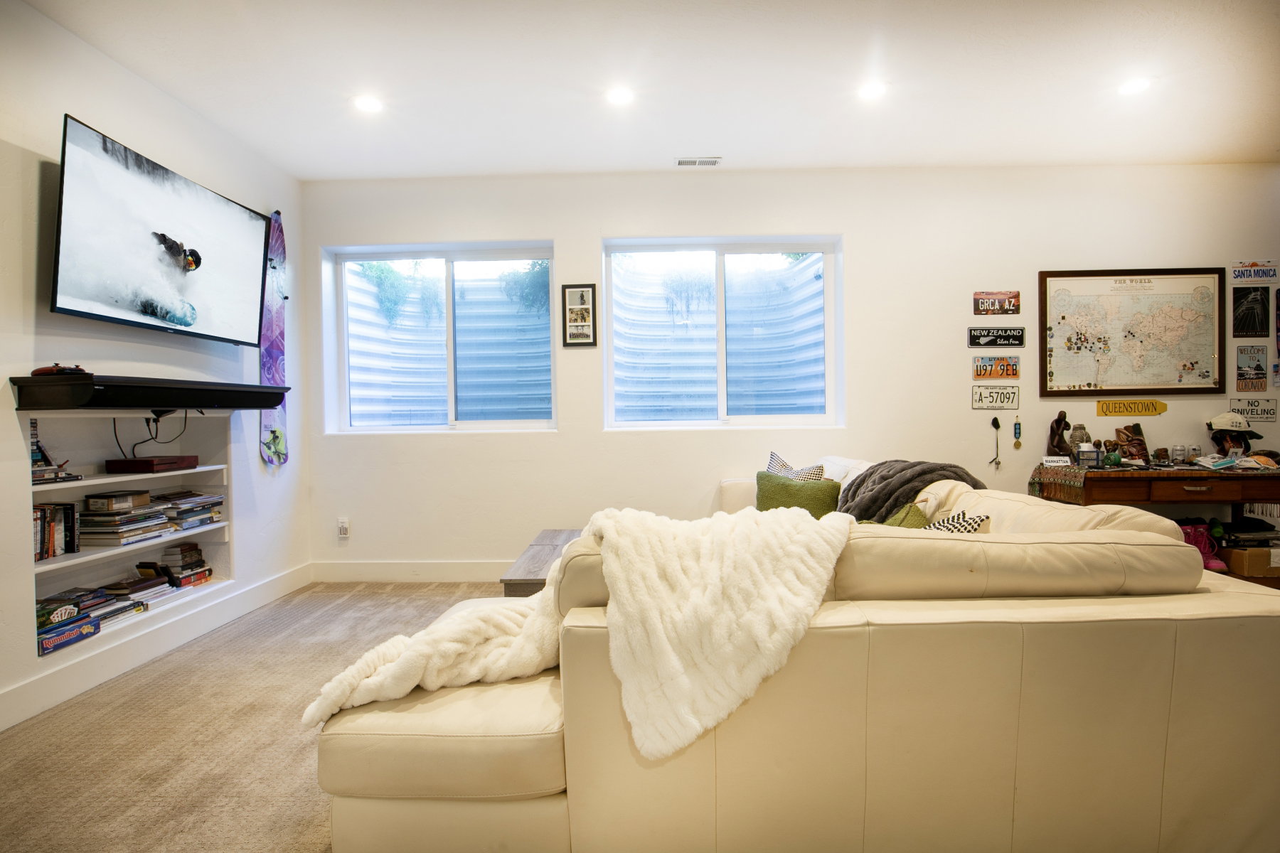 Carpeted room featuring recessed lighting, a built-in entertainment unit with shelving, and two windows