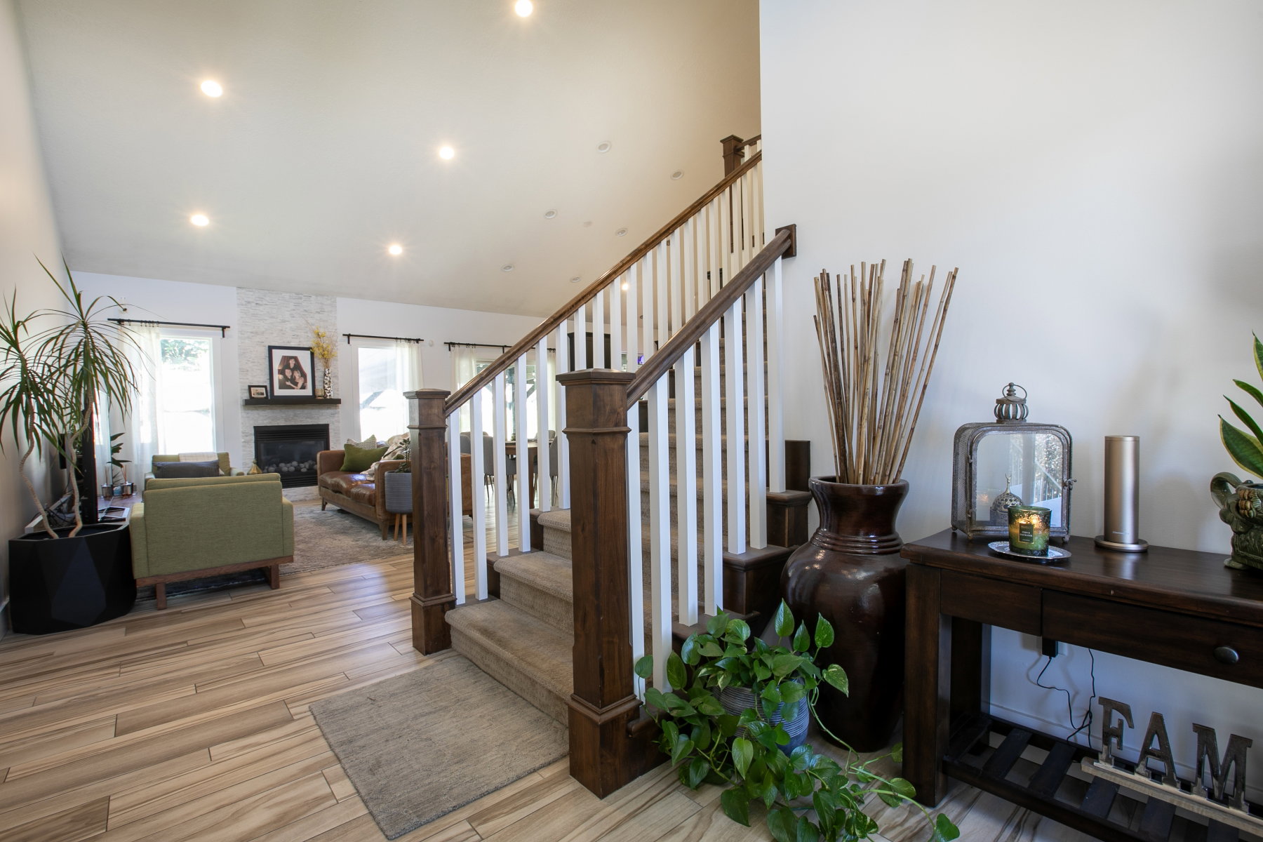 Inviting entryway with wood-finish flooring and a staircase featuring dark wood newel posts and white balusters