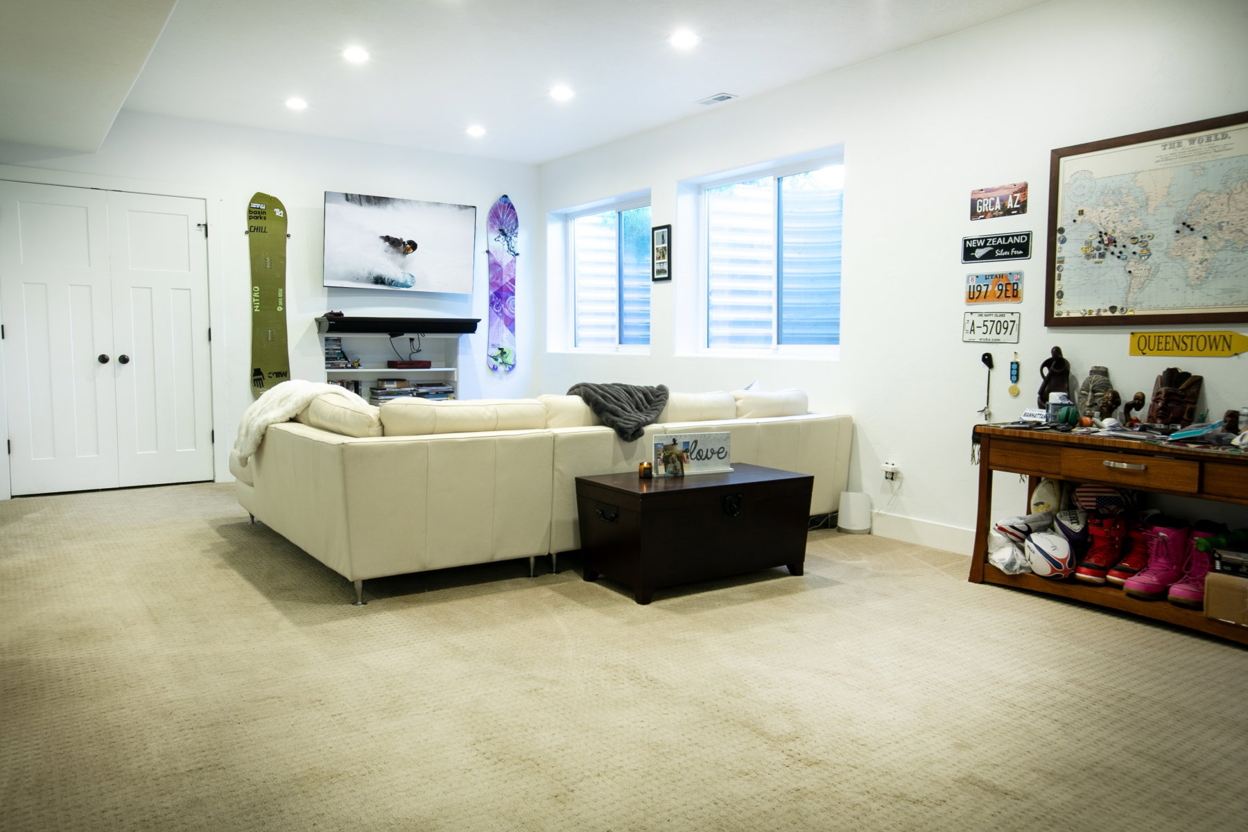 Carpeted recreation room featuring recessed lighting, white trim, and two egress windows
