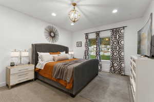 Bedroom featuring light colored carpet and hanging lights