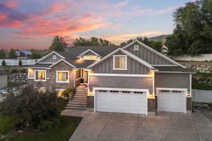 Craftsman house with board and batten siding, driveway, a garage, and roof with shingles