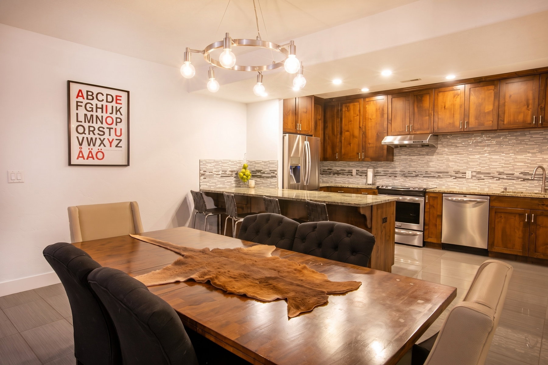 Open-concept dining area with wood-finish flooring, a contemporary chandelier, and recessed lighting
