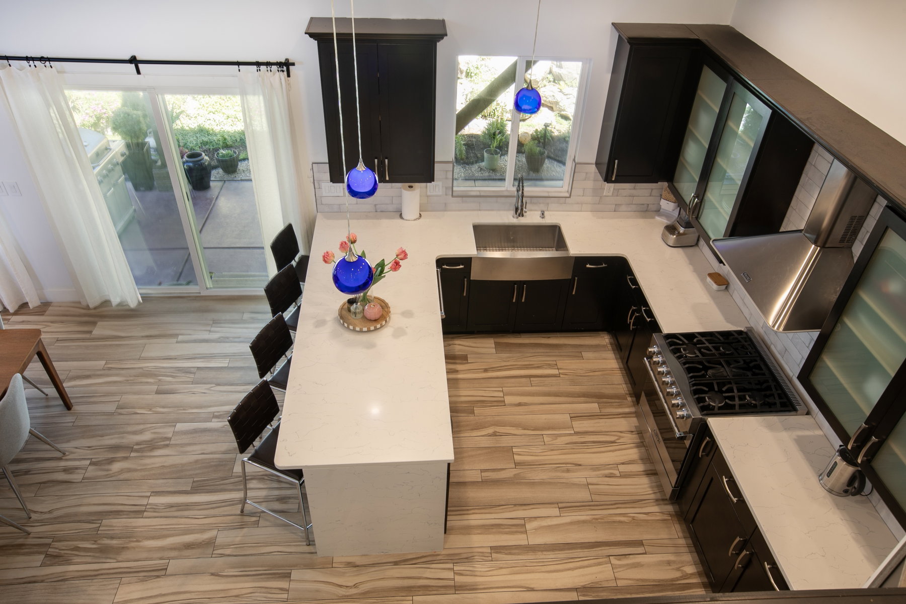 Modern kitchen featuring dark cabinetry, stainless steel appliances, and white countertops