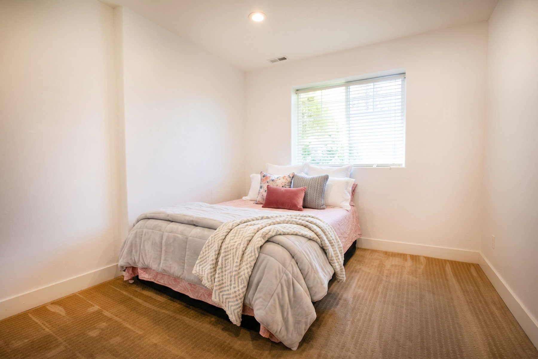 Room featuring neutral wall tones, recessed lighting, and a single window with blinds