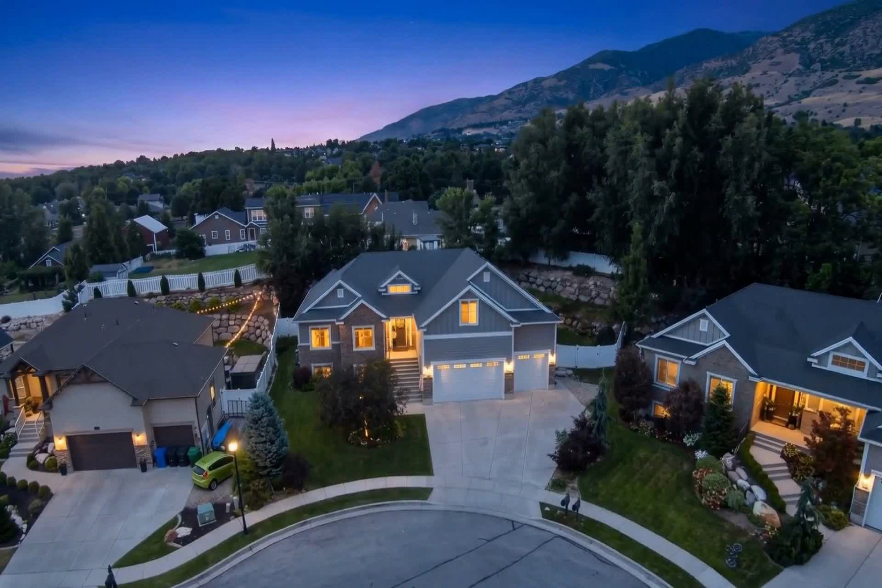 Contemporary residence featuring a two-car garage, stone and siding exterior, and a covered front entry