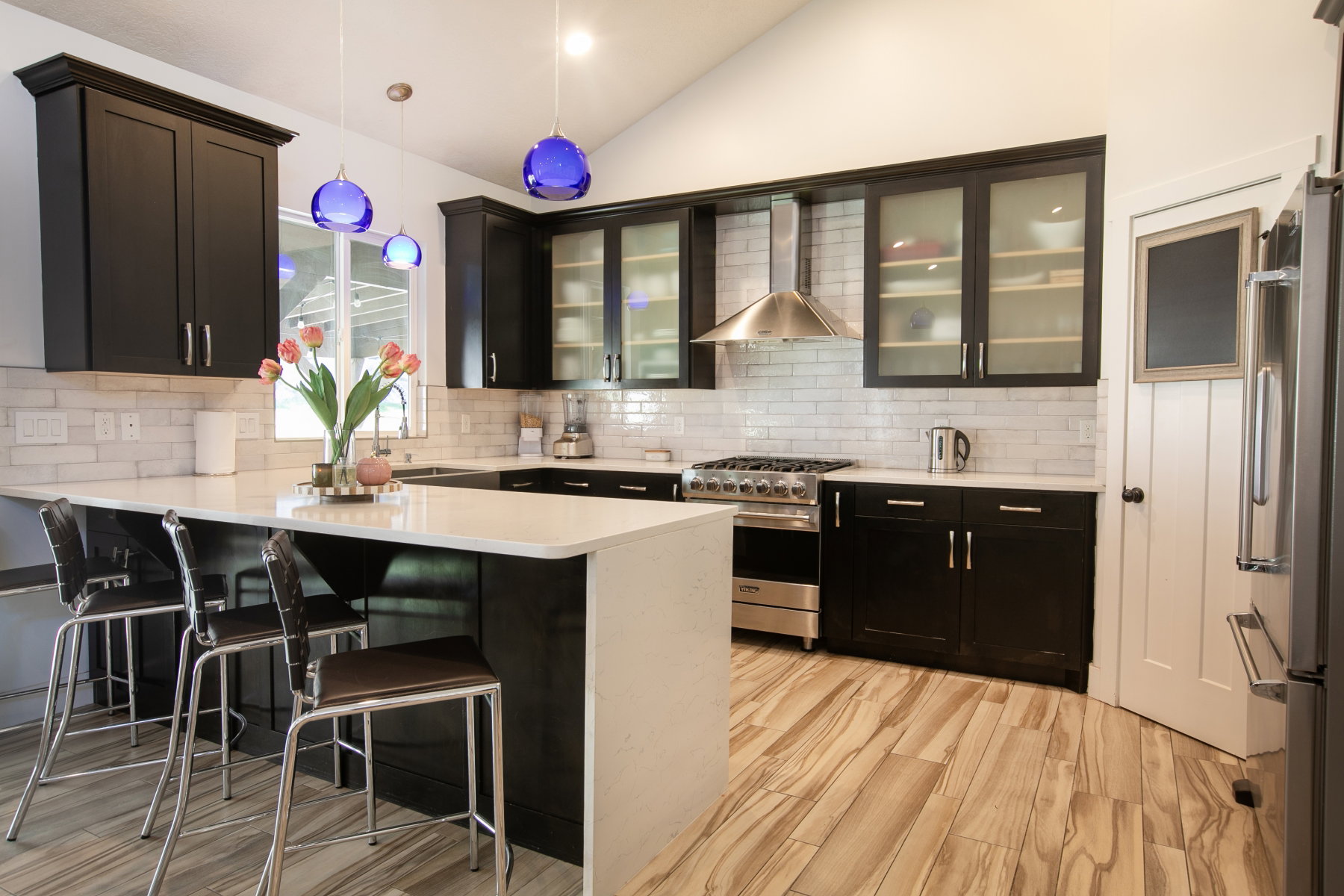 Modern kitchen with vaulted ceiling and wood-finish flooring