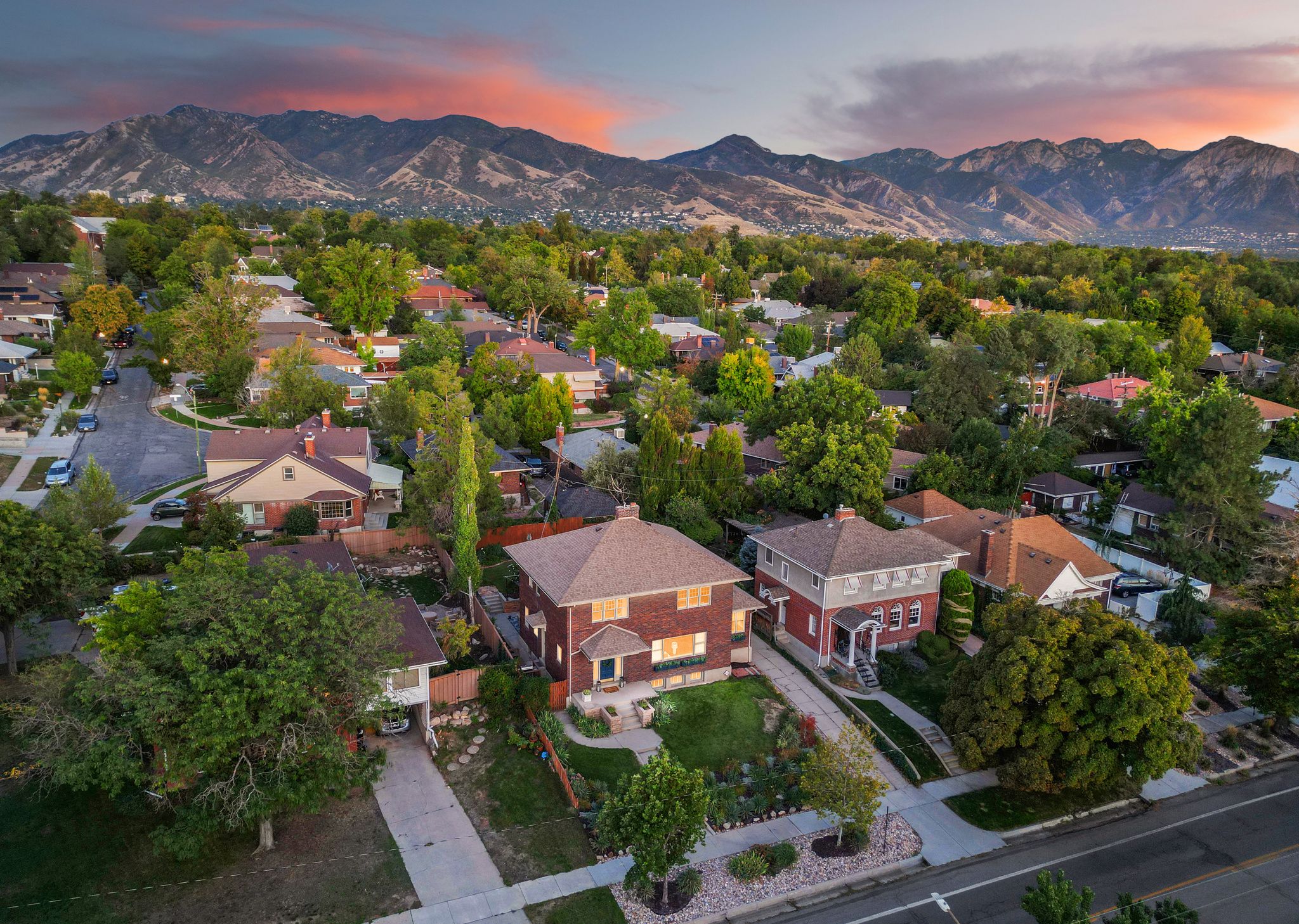 Residential neighborhood featuring mature trees and mountain scenery