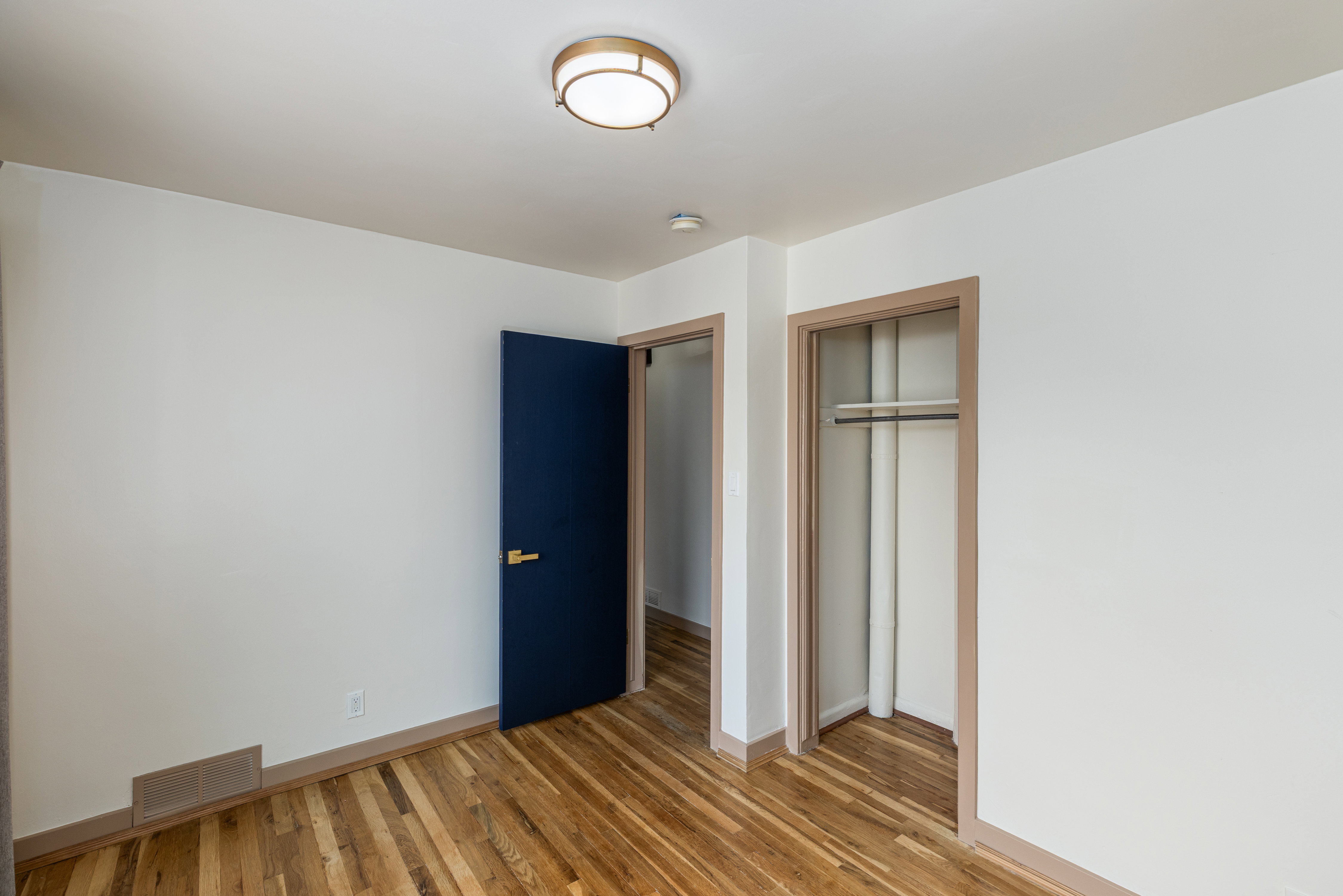 Room featuring wood-finish flooring and a contemporary flush-mount ceiling light