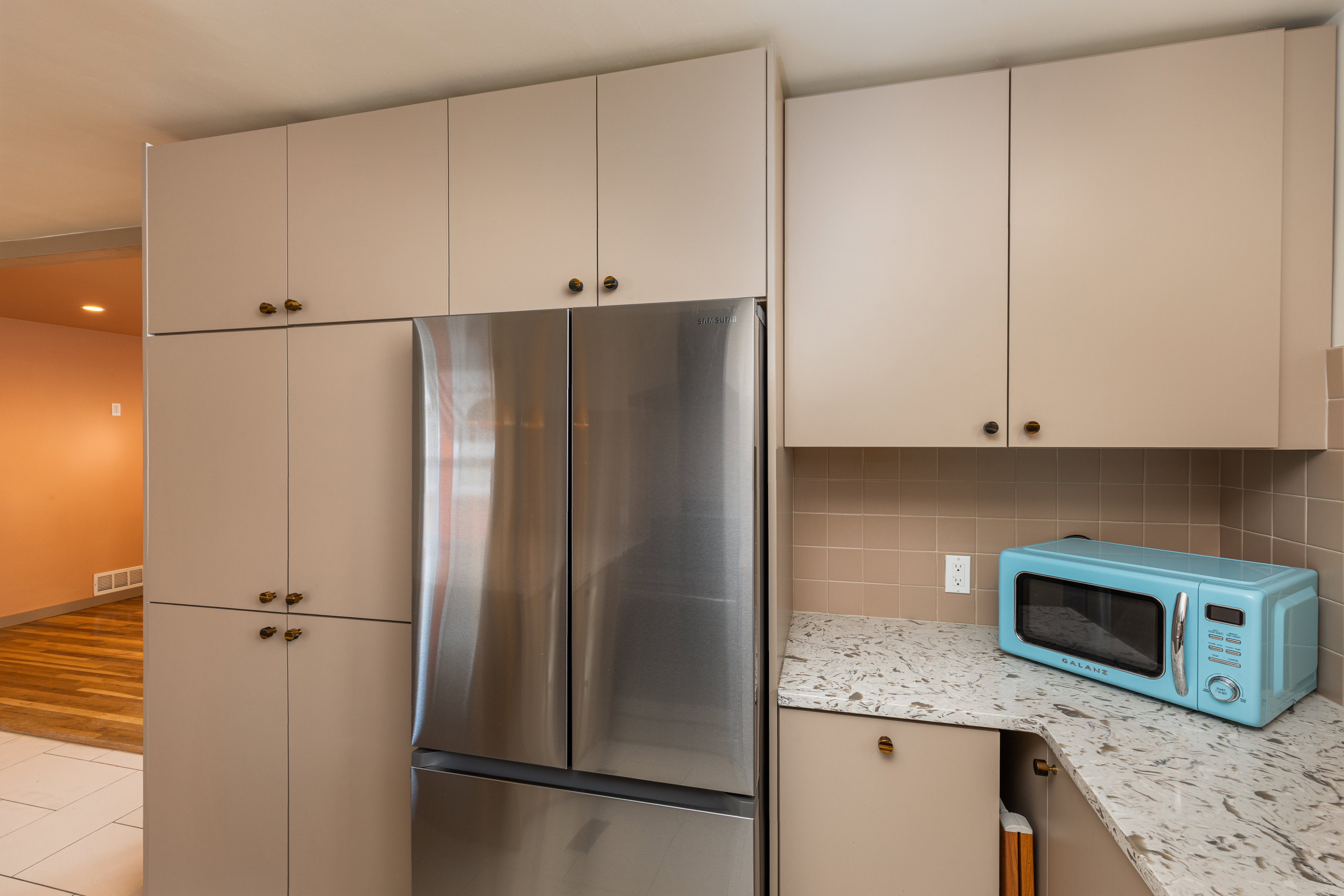 Integrated stainless steel refrigerator framed by custom cabinetry