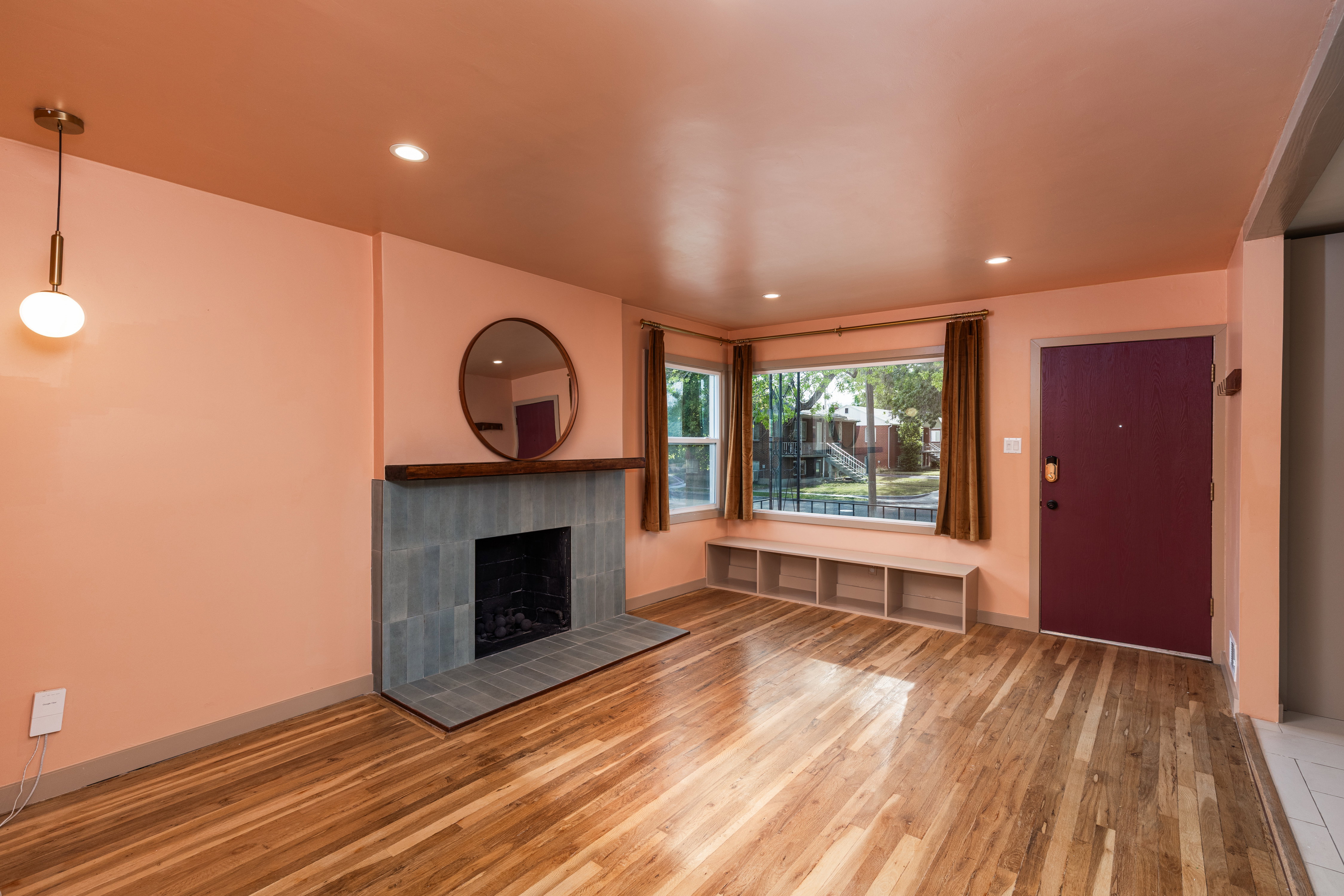 Living area featuring wood-finish flooring, recessed lighting, and a modern fireplace with a tiled surround and dark wood mantel