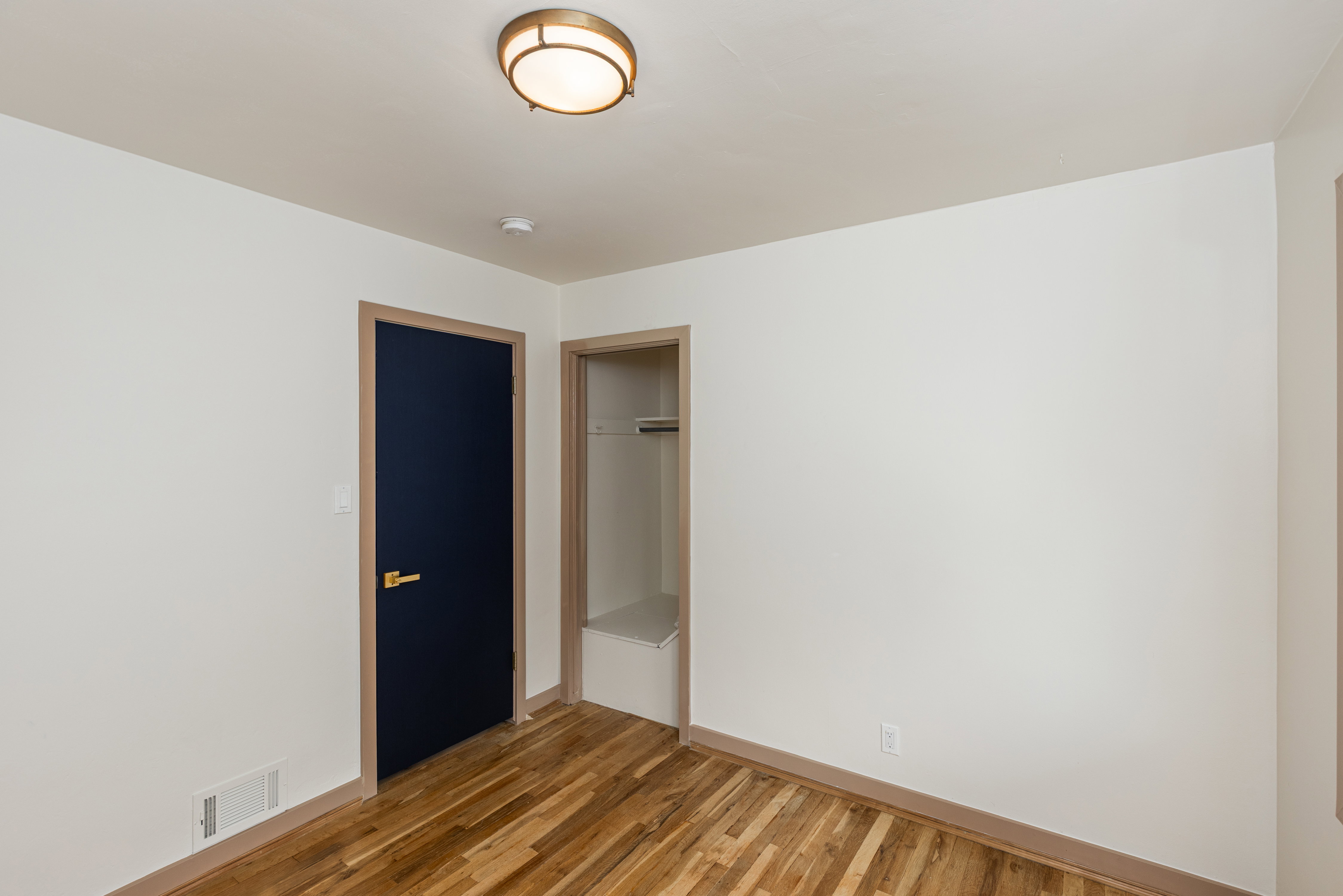 Room featuring wood-finish flooring and white painted walls
