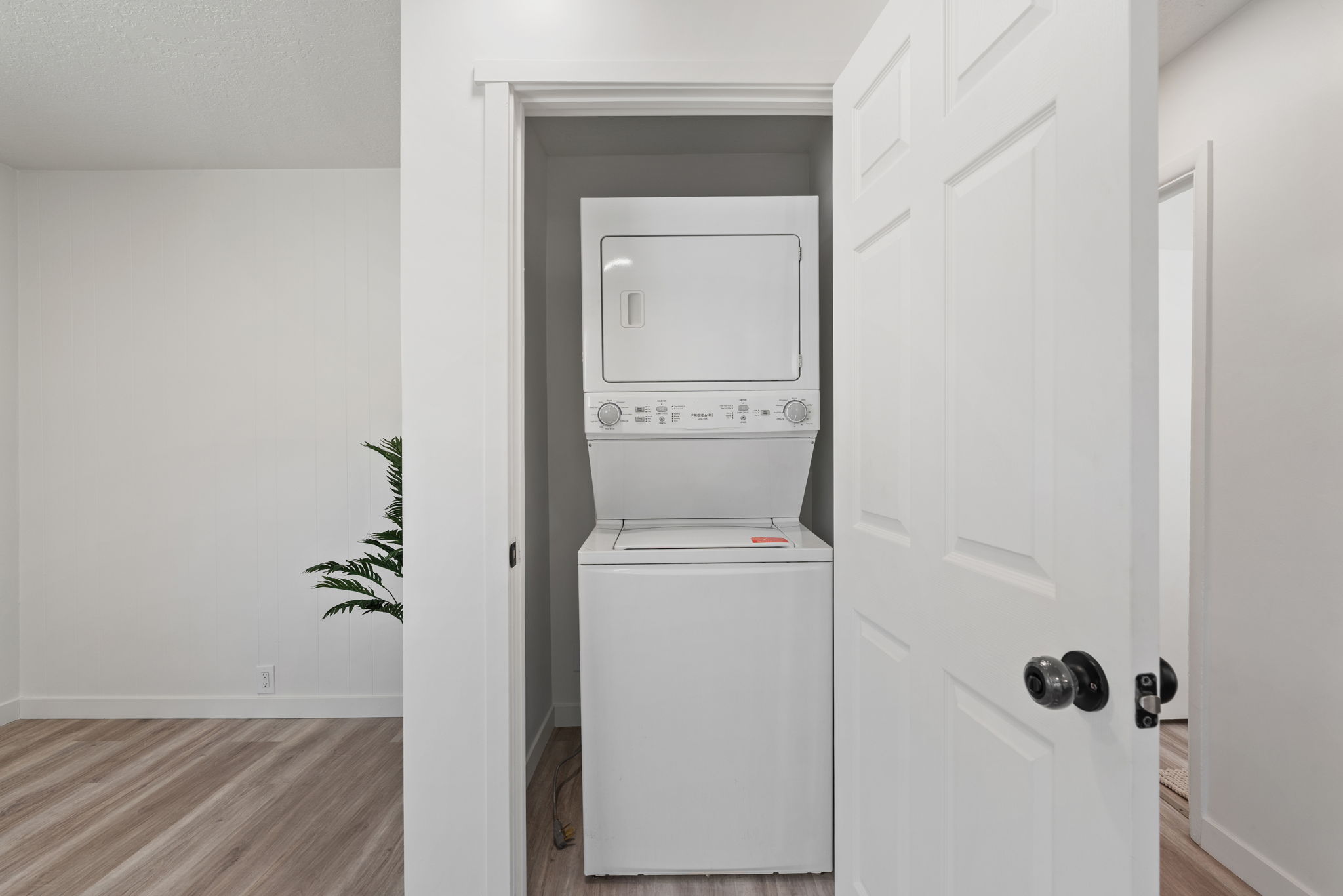 Integrated laundry closet with white stacked washer and dryer