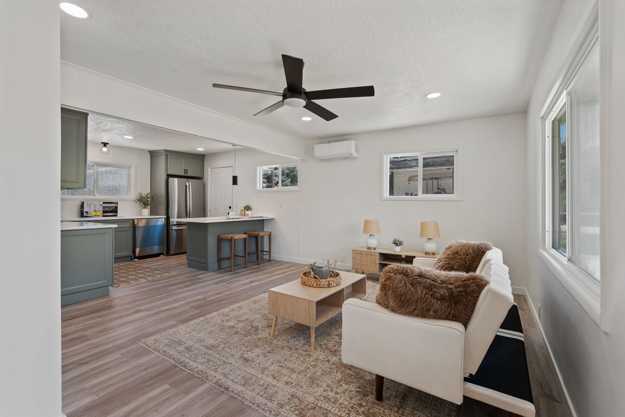 Open-concept living area with wood-finish flooring, recessed lighting, and a ceiling fan